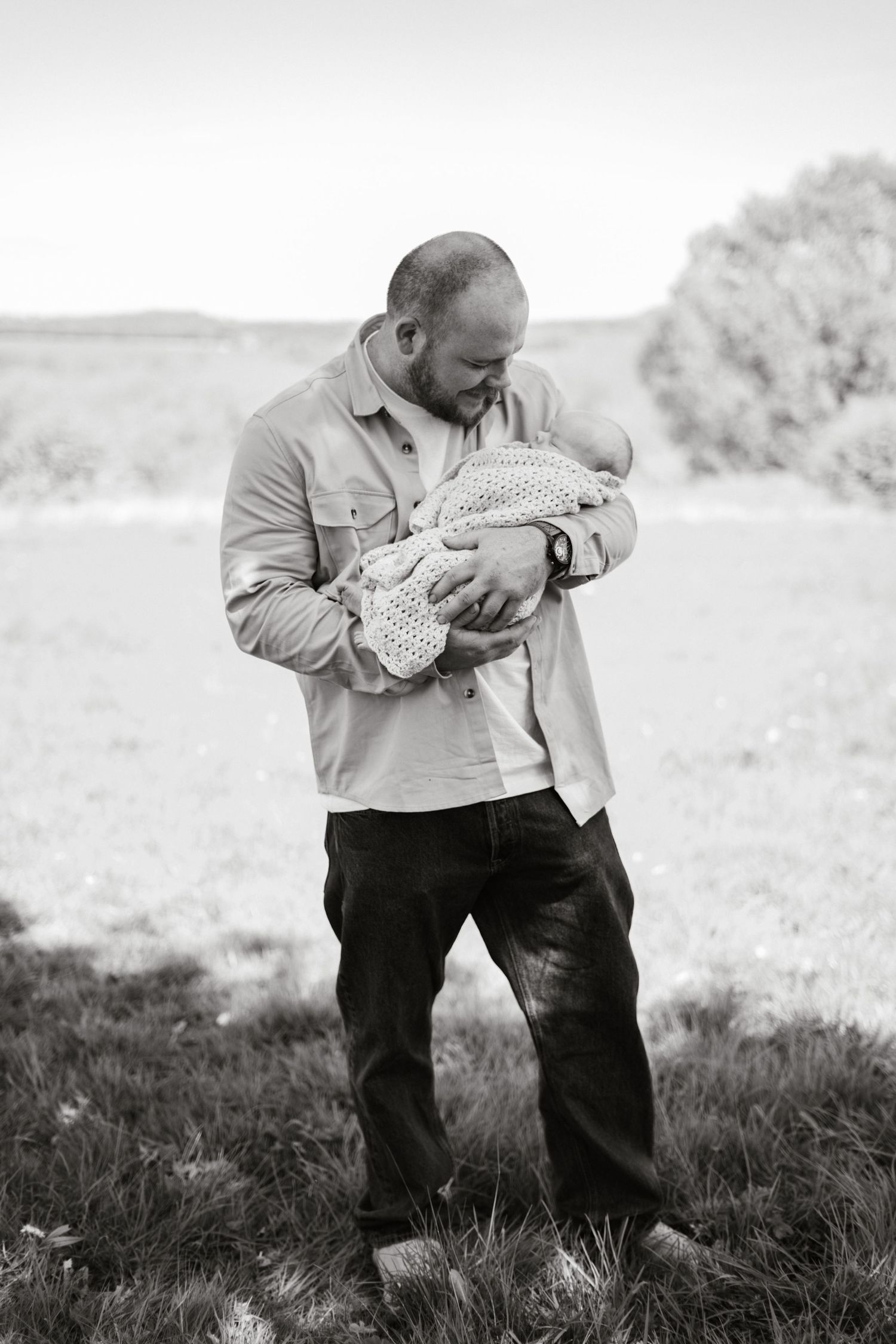 A sequence of black and white images showing tender moments in a grassy field.