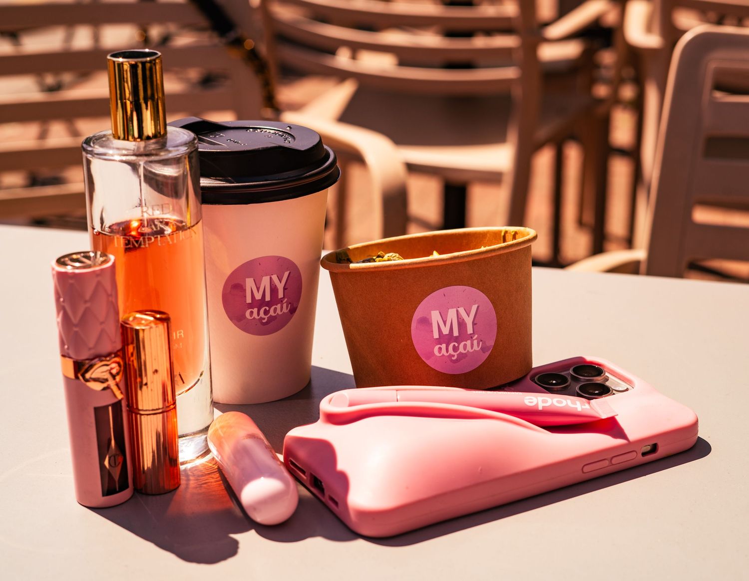 Pink branded food containers and packaging arranged in warm lighting on a wooden surface.