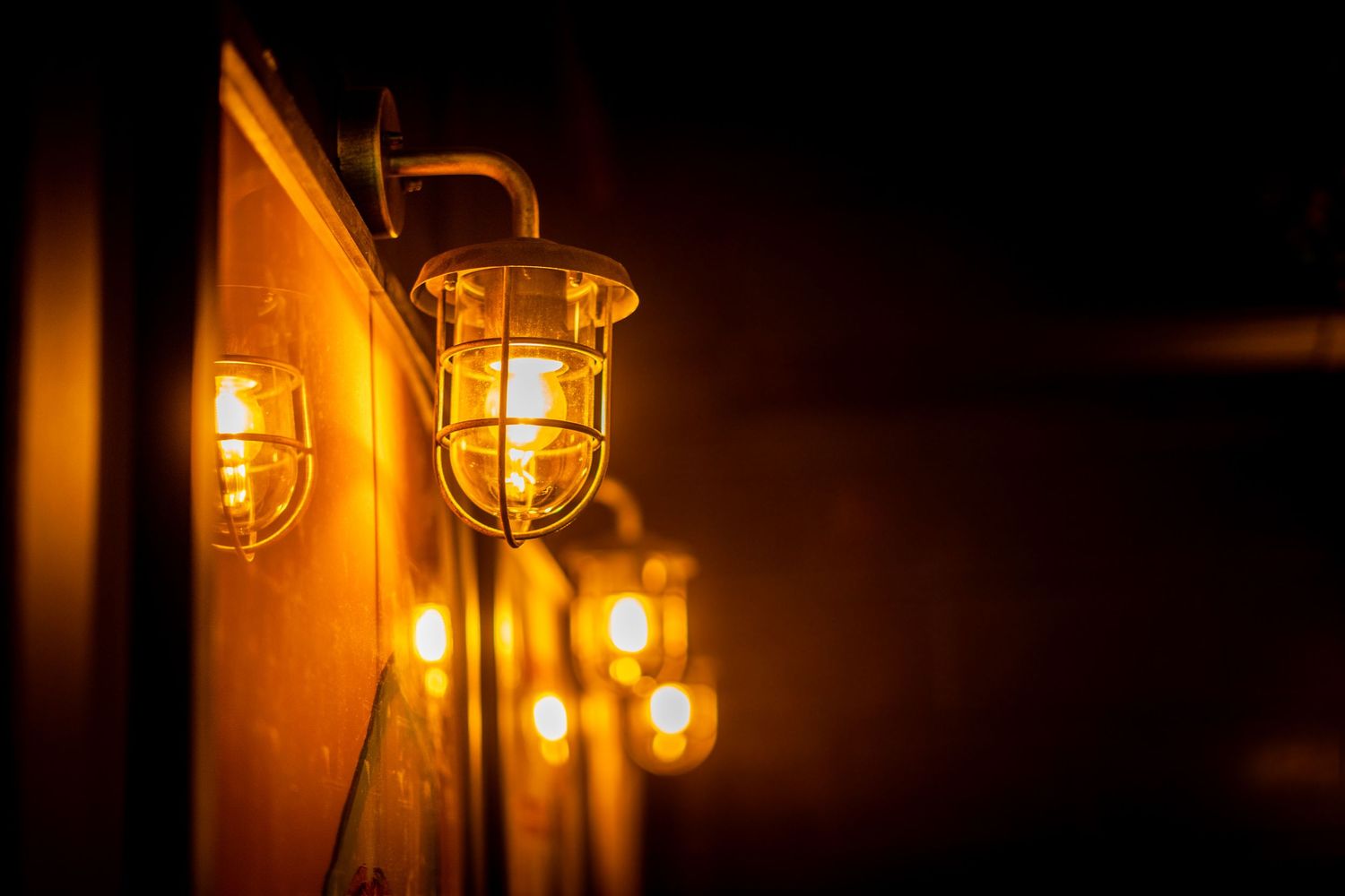 Industrial-style pendant lights casting warm glows against a dark background.