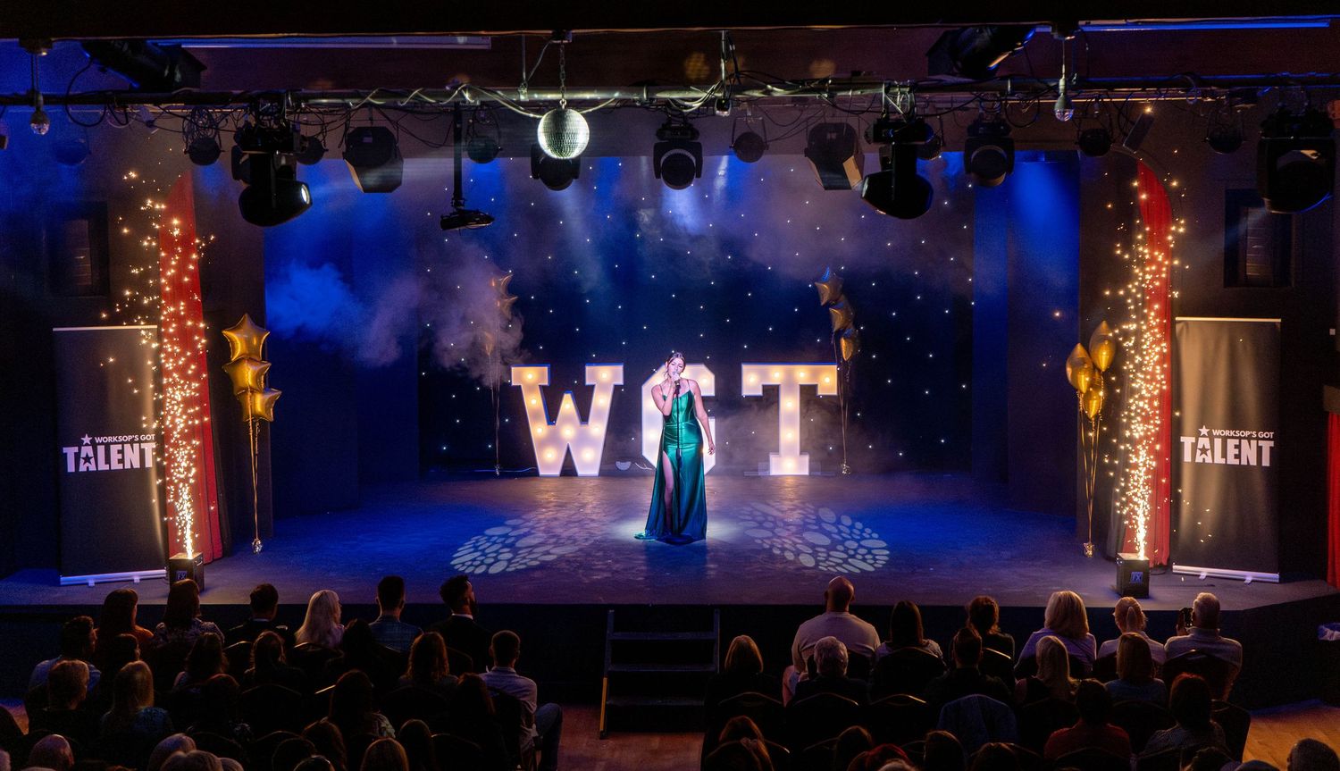 Stage performance with 'WCT' text display and dramatic lighting effects.