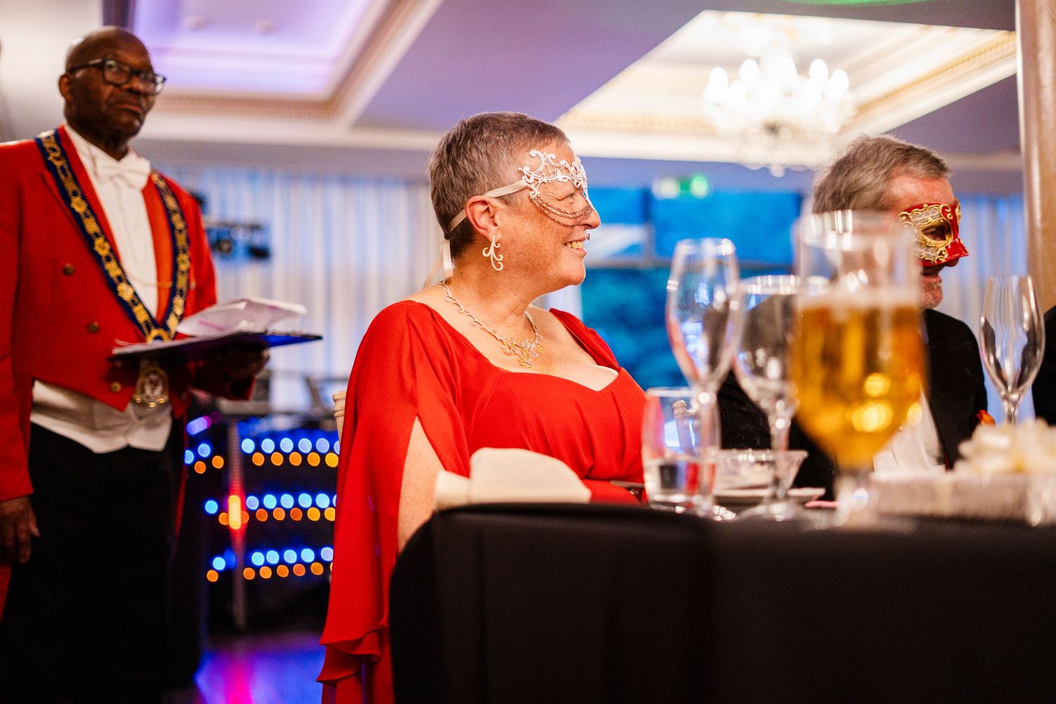 Guests enjoying drinks and conversation at an elegant indoor reception with warm lighting.