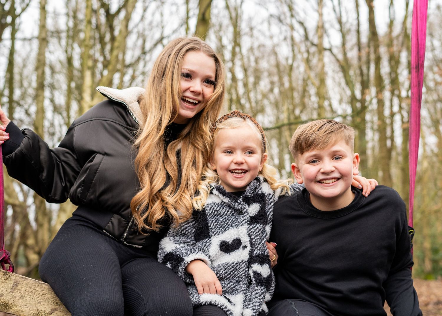 Casual family photo session on a forest slope with natural winter lighting.