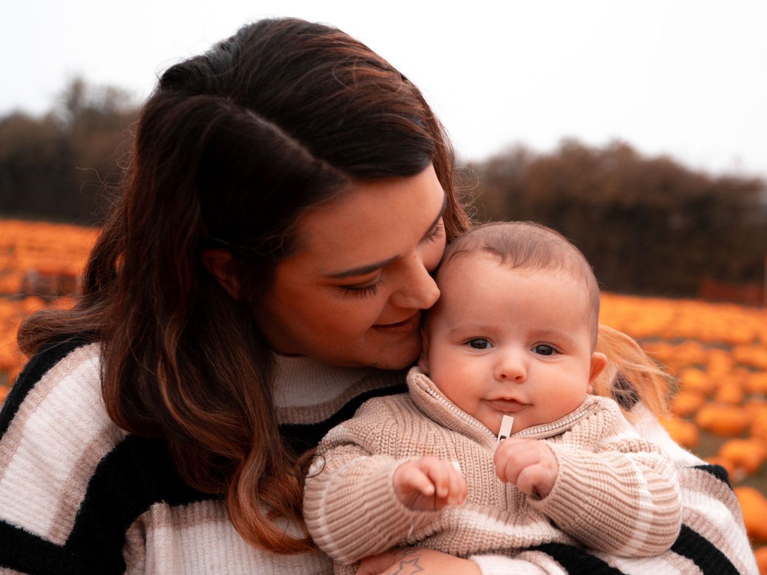 Tender moment between parent and child in warm autumn lighting.