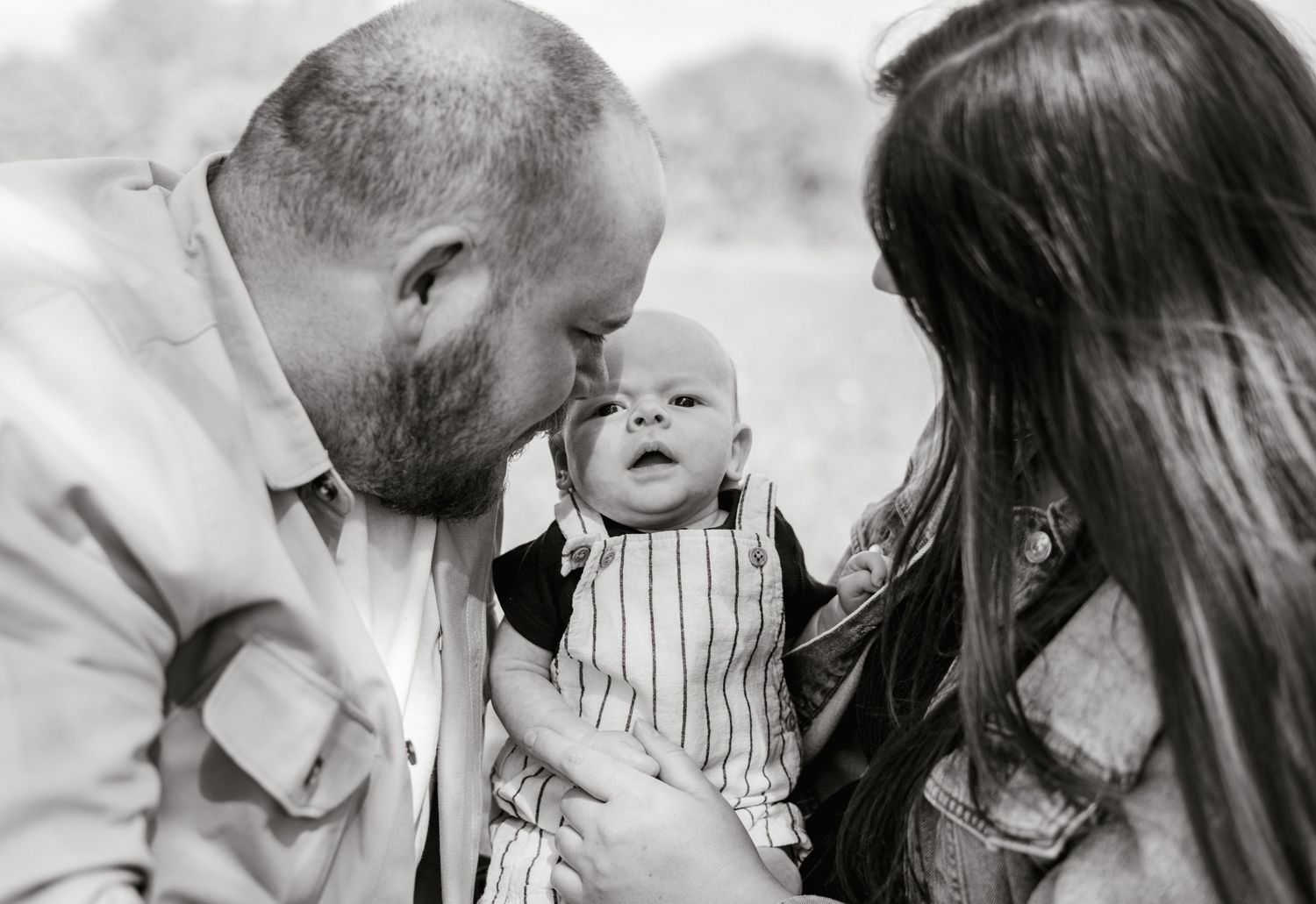 Black and white intimate family portrait outdoors.