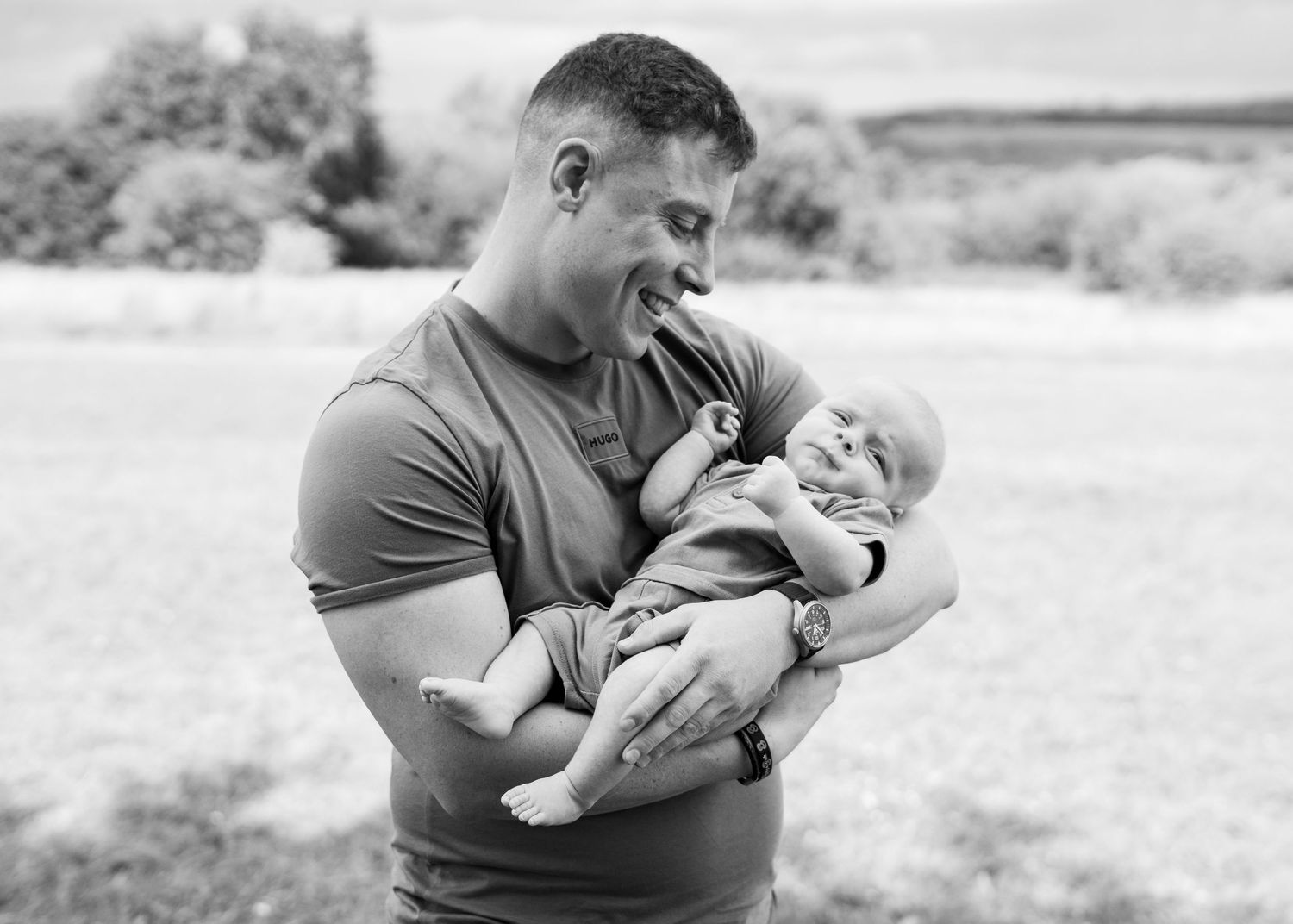 Monochrome capture of gentle interaction with baby outdoors.