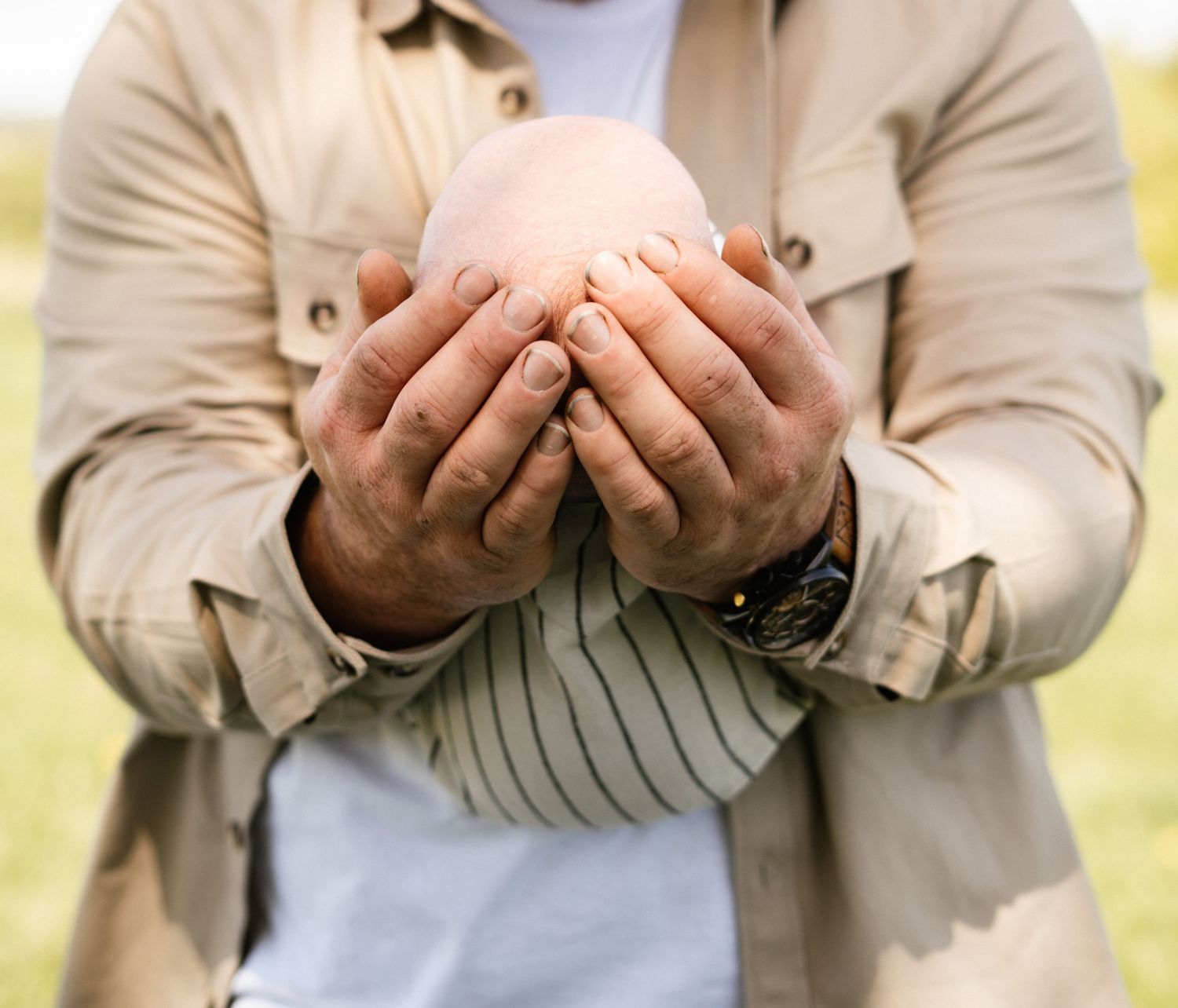 Close-up shots of hands gently holding a small object in sequence.