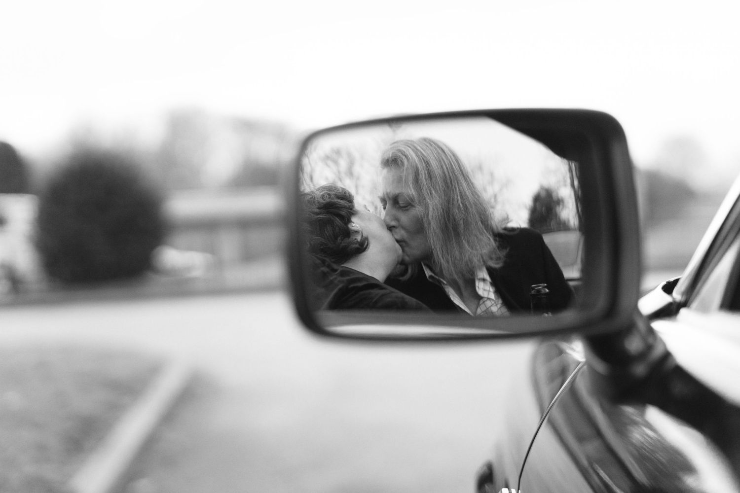 Artistic black and white photo captured through a car side mirror.