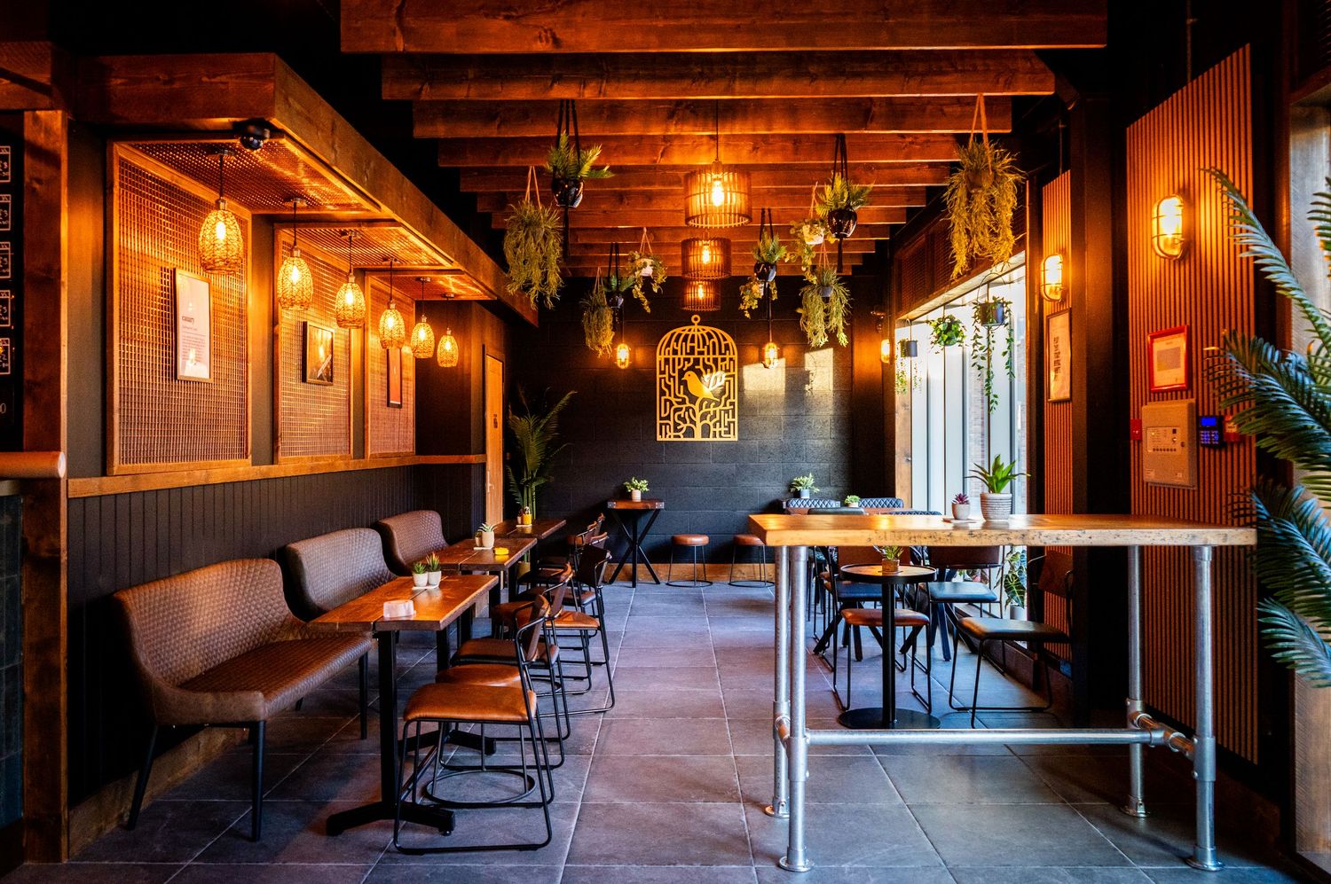 Cozy restaurant interior with wooden beams, pendant lights, and comfortable seating arrangements.