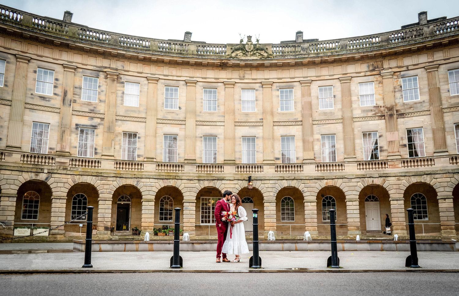 Panoramic view of a grand curved stone colonnade with classical architecture and arches.