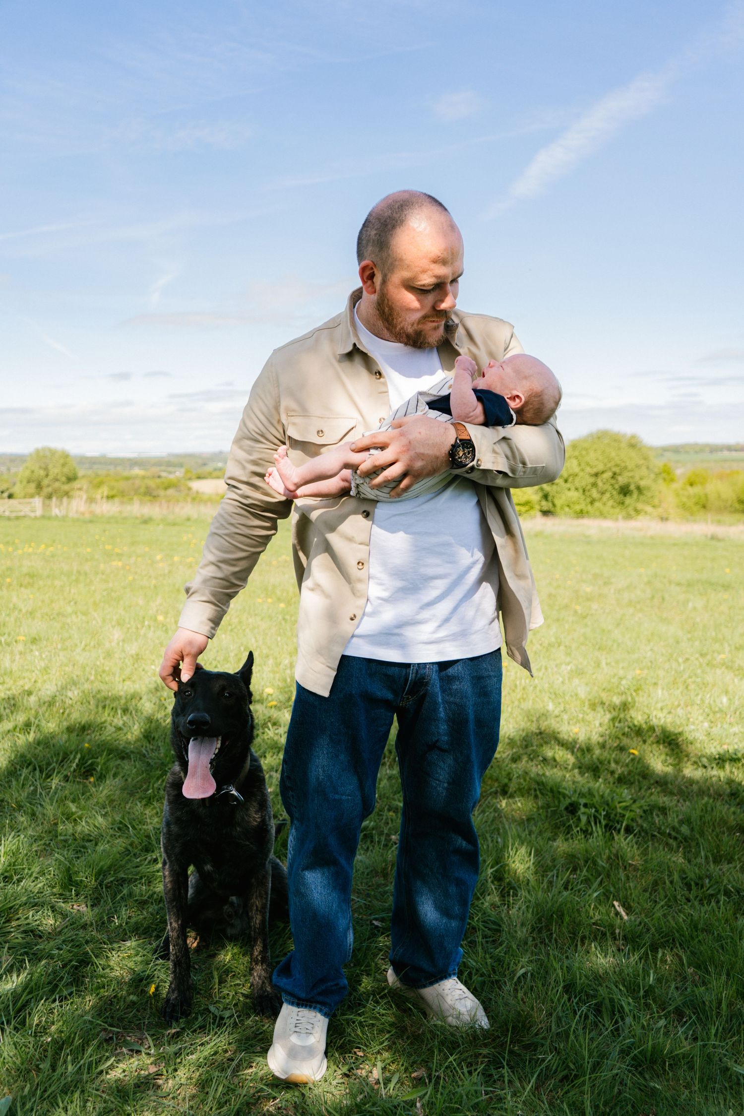 A sunny outdoor scene showing tender moments between people and a small infant.