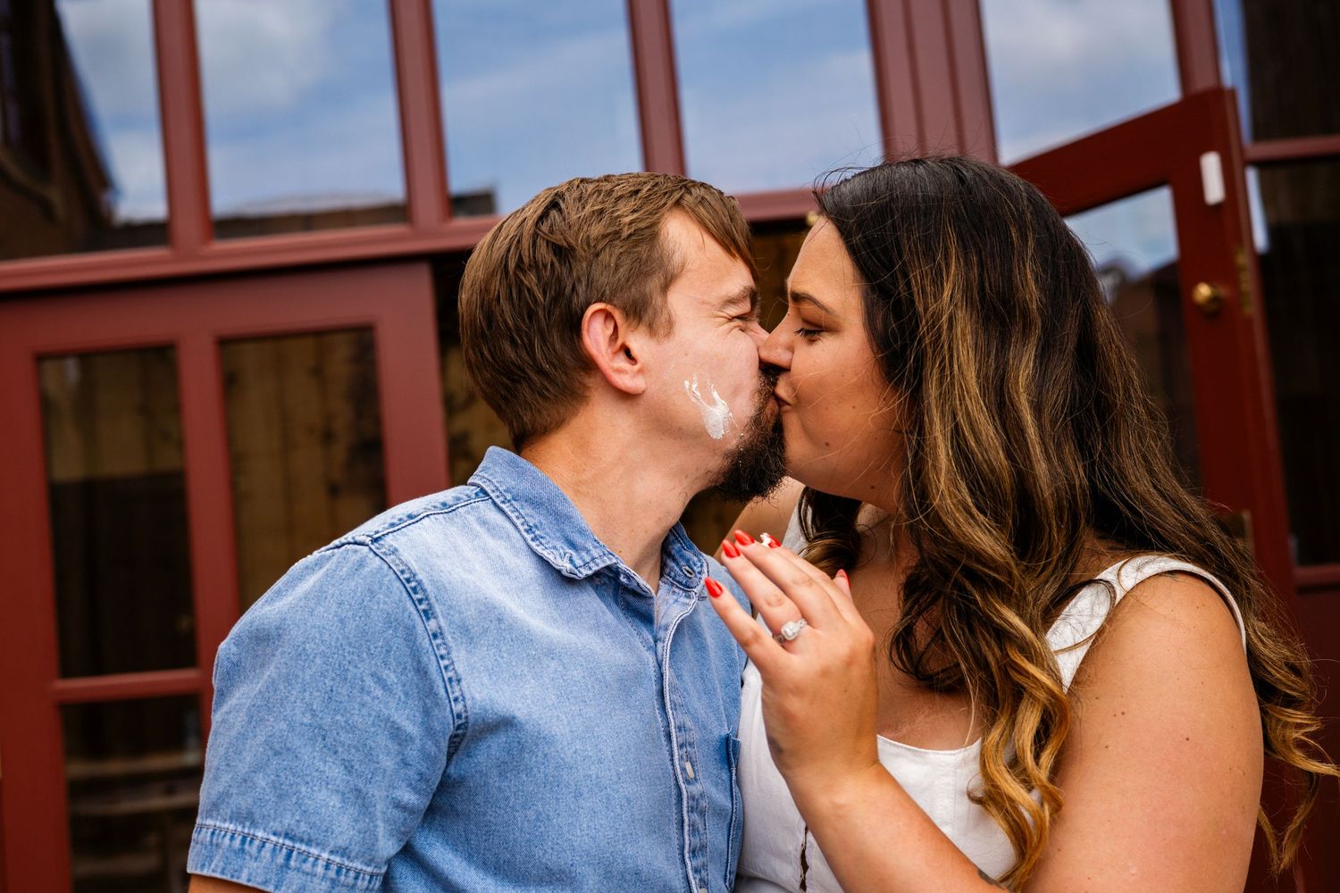 A romantic couple sharing an intimate moment in front of a brick wall.