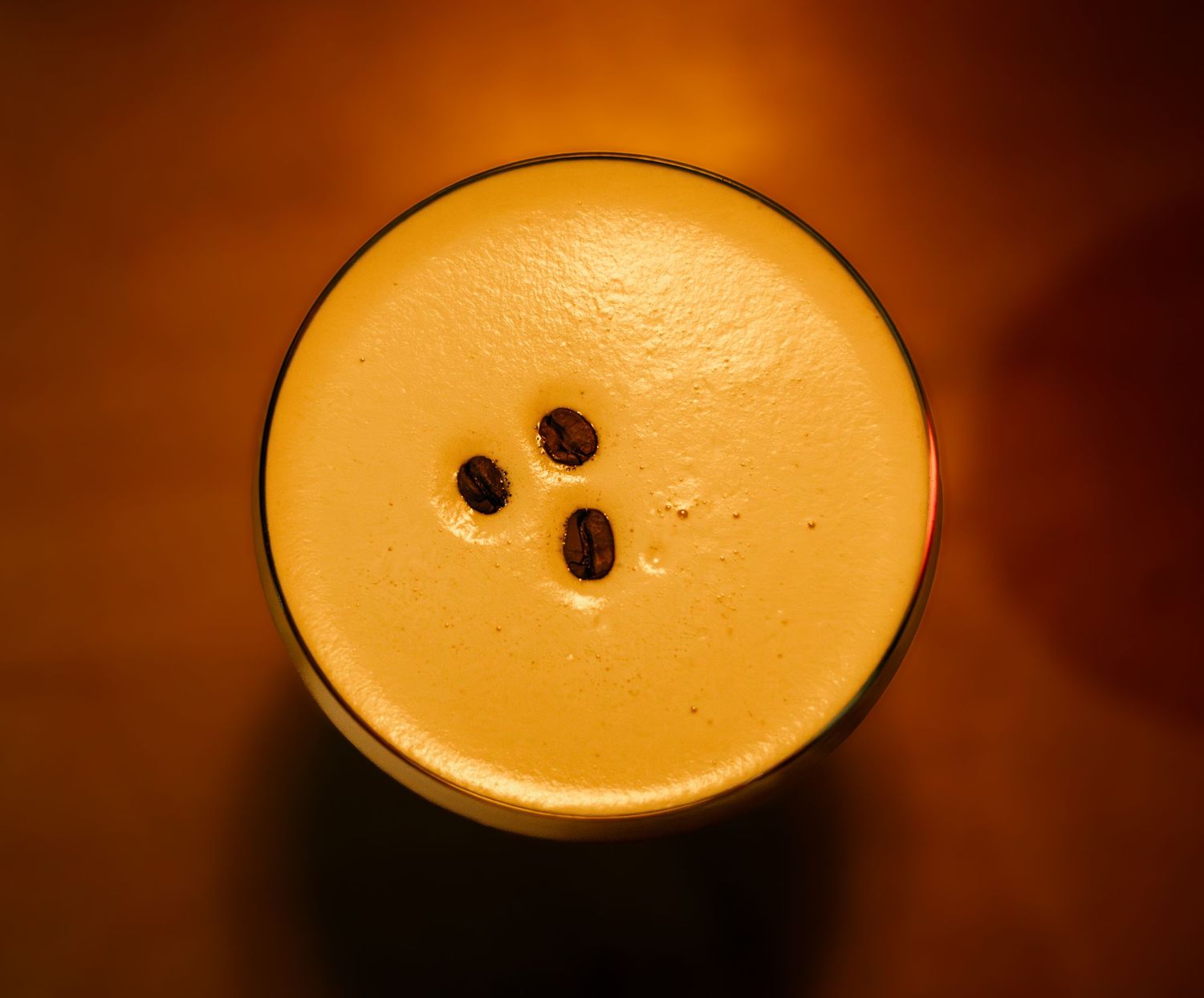 Creamy espresso martini with rich foam top photographed in warm lighting.
