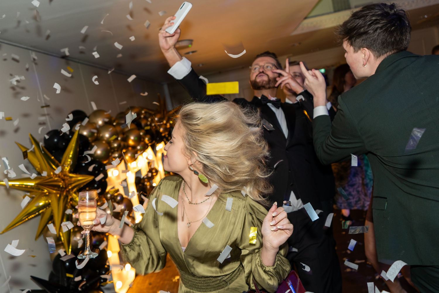 Confetti falling during a celebration with golden lighting effects.