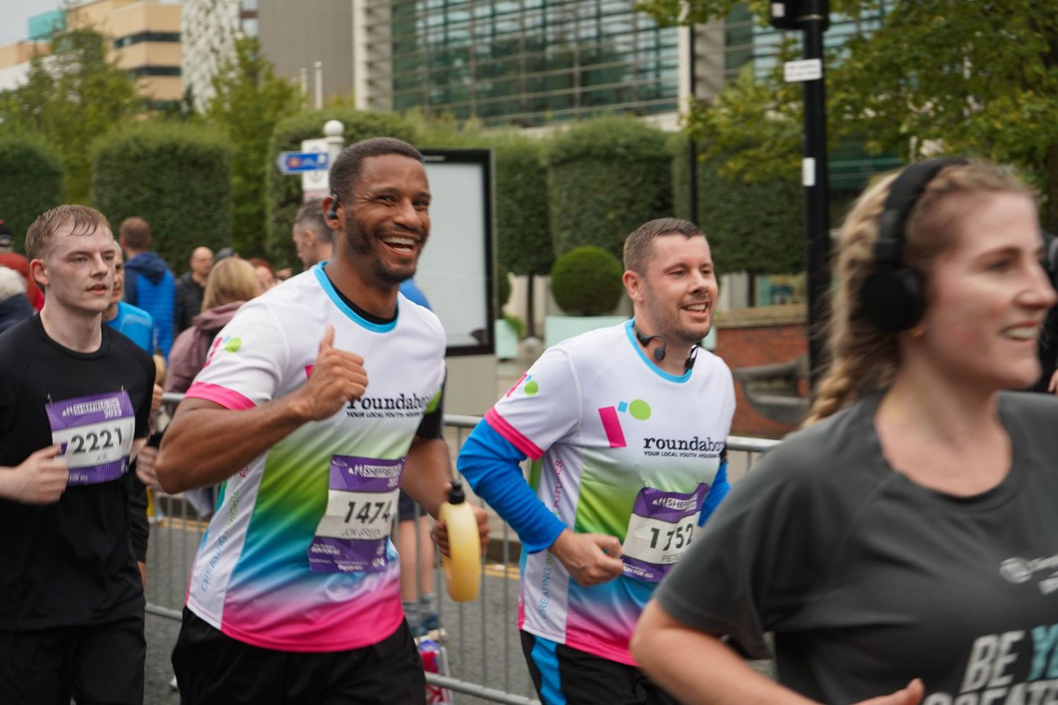 Runners showing enthusiasm while participating in an urban road race event.