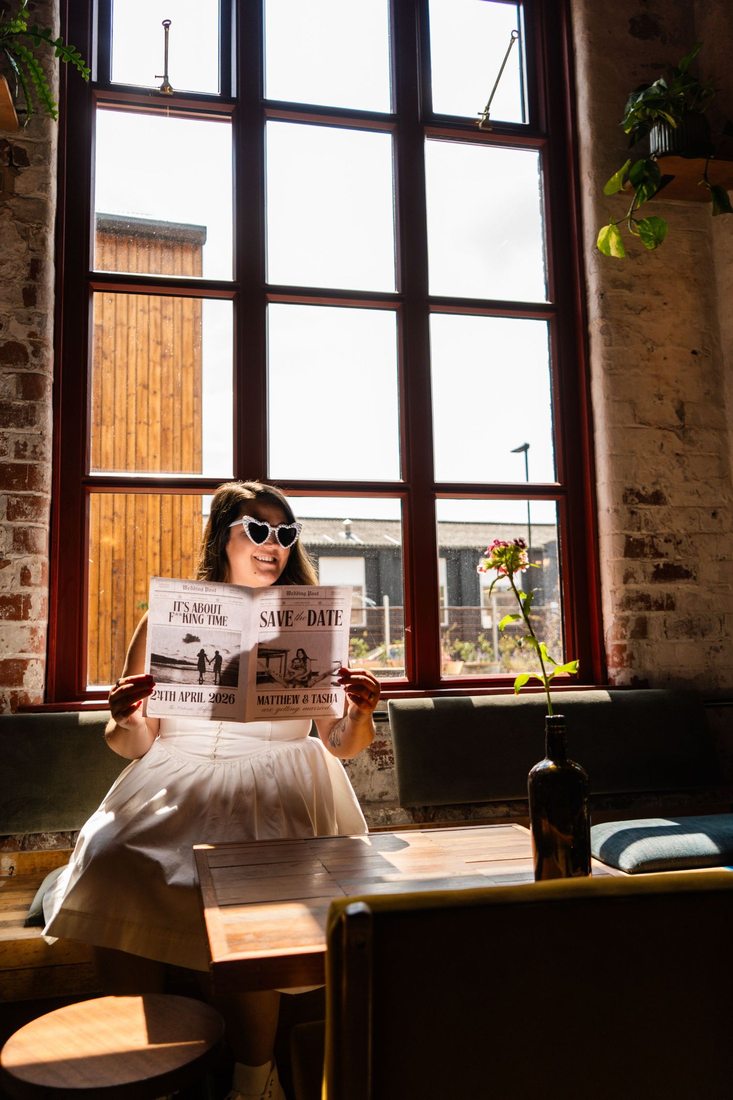 Sunlit industrial space with exposed brick walls and large windows.