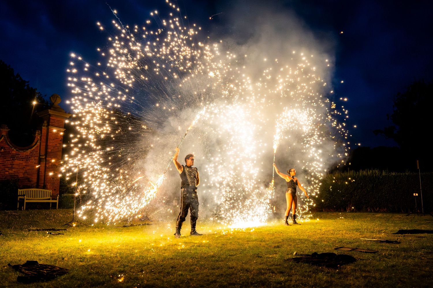 Spectacular nighttime sparkler display creating trails of light against dark sky.