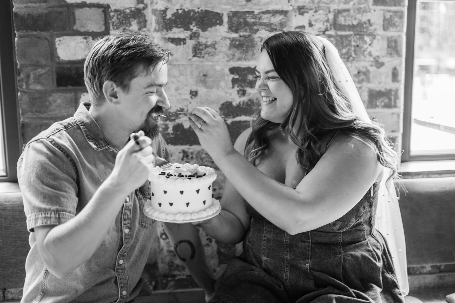 A couple sharing a romantic moment in an industrial brick setting.