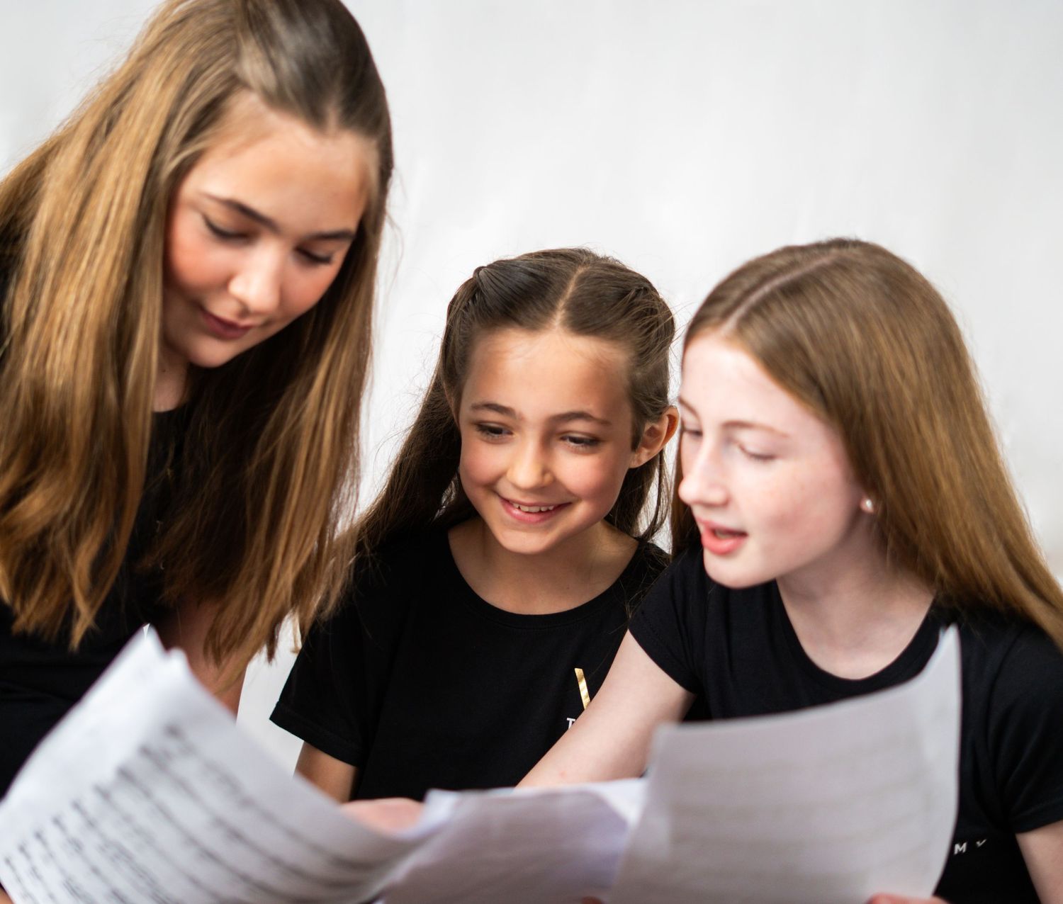 Students collaborating while reading sheet music together.