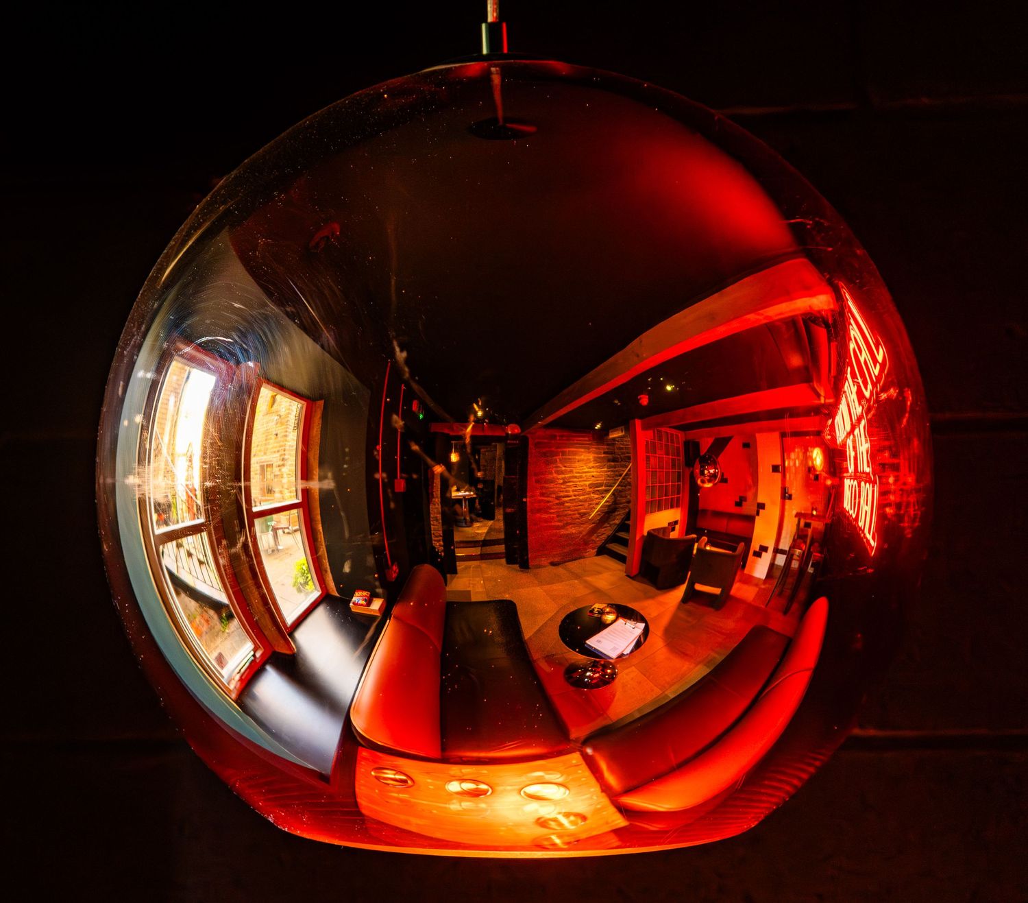 Fish-eye view of a red-lit interior space with industrial design elements.
