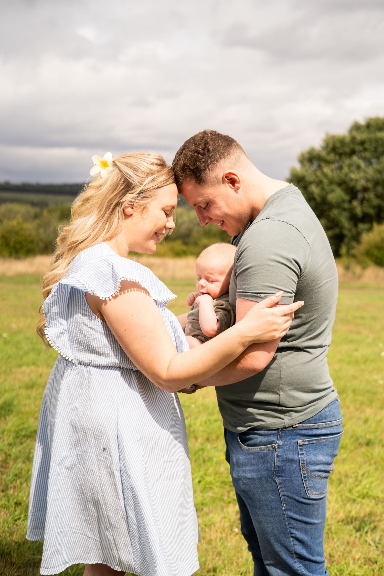 Couple sharing an emotional moment together in a sunny outdoor field.