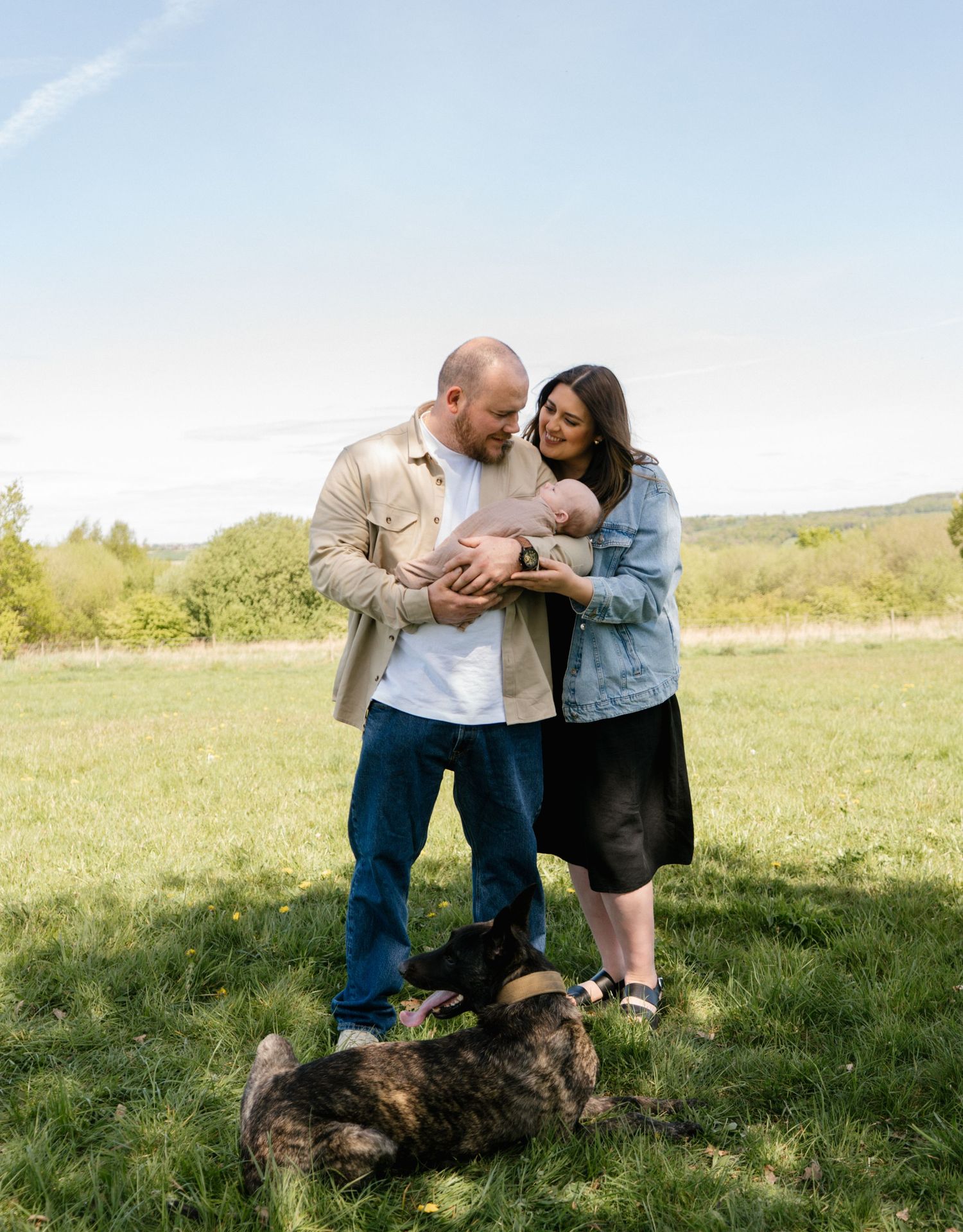 Family portrait session in a sunny meadow with natural expressions.