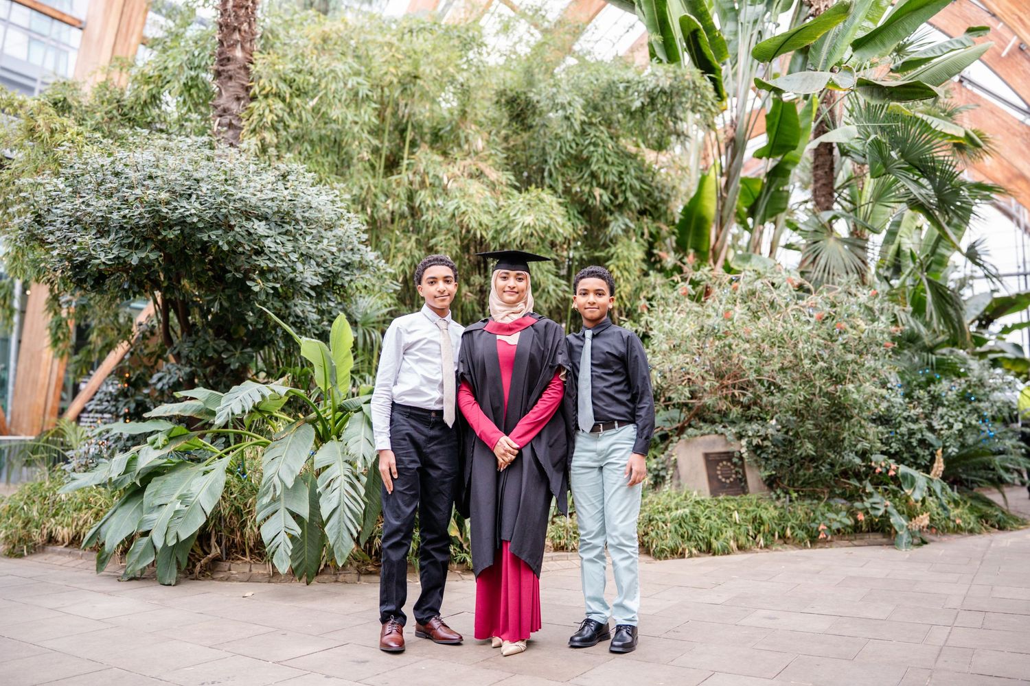 Wide garden view with tropical plants framing graduation family photo session.