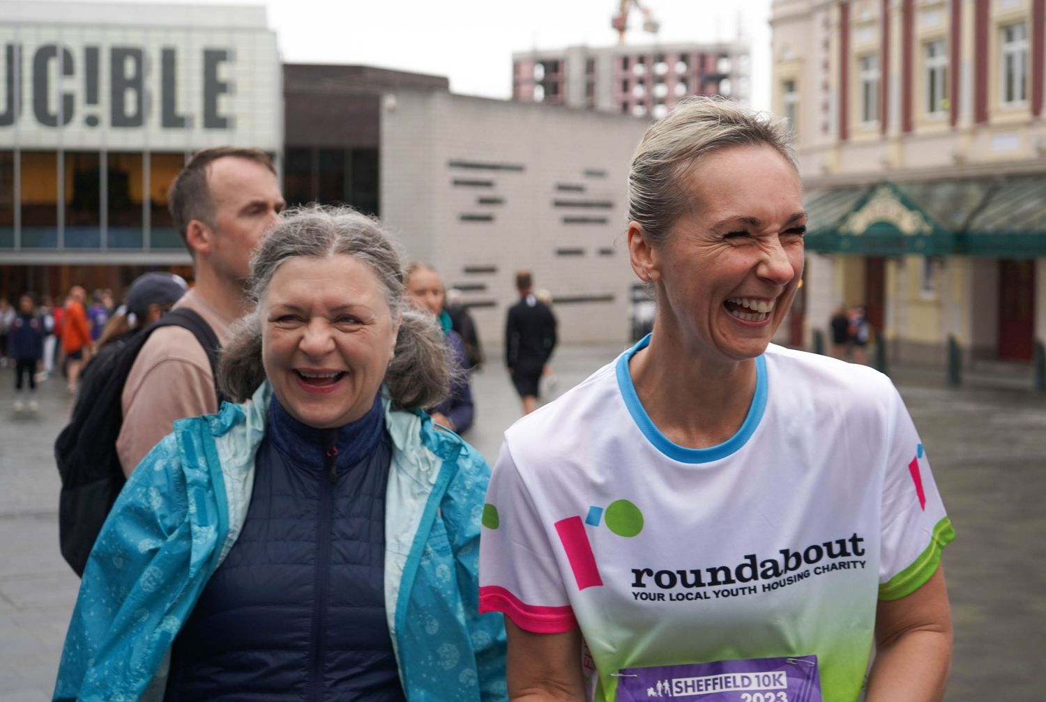 Group of runners smiling during an outdoor charity event.