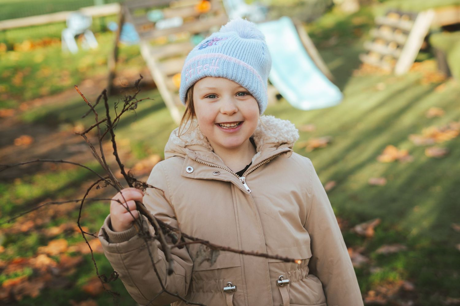 Child in winter clothing exploring outdoors during autumn season.