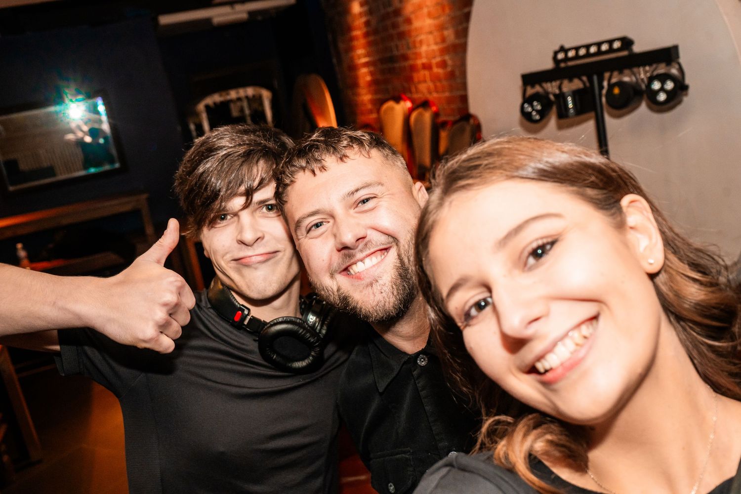 Group of friends taking a selfie together in a music venue.