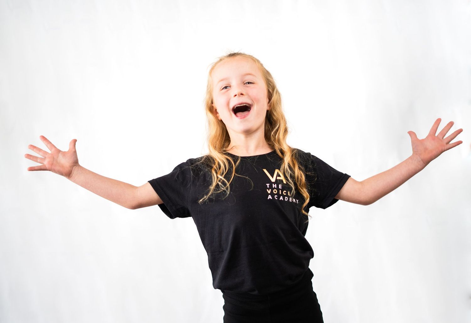 Students expressing joy and enthusiasm during a performing arts class.