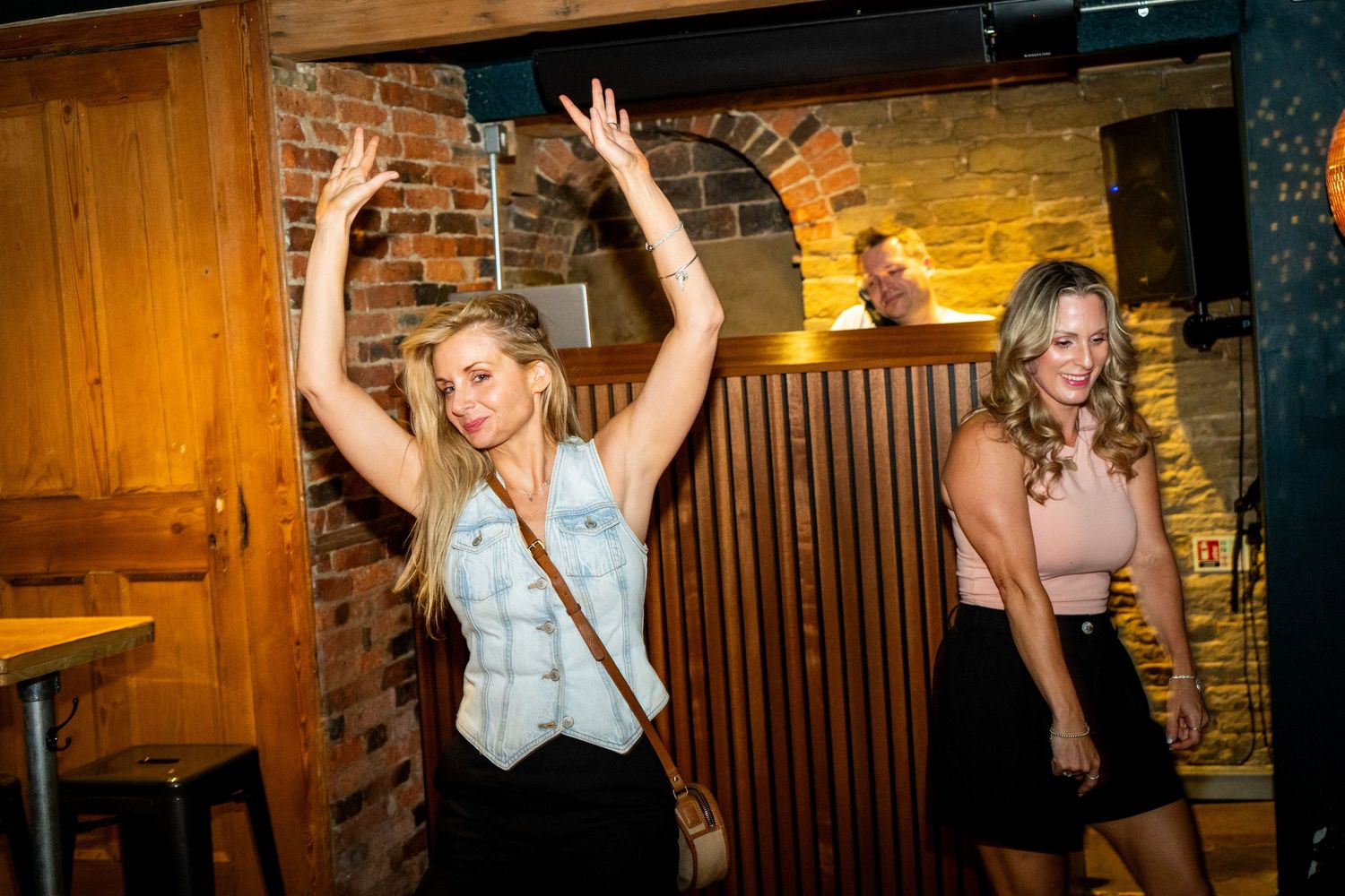 Energetic nightlife scene with partygoers dancing and celebrating.