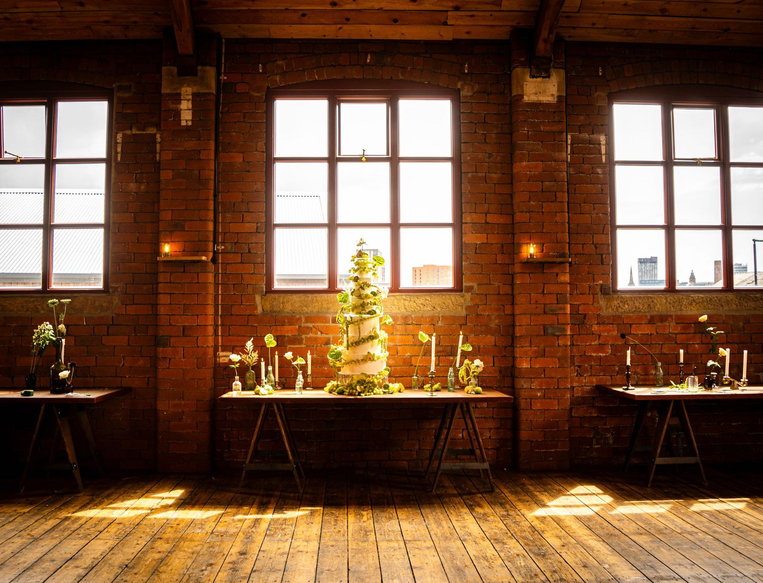 Sunlight streams through windows in a rustic brick-walled room with wooden floors.