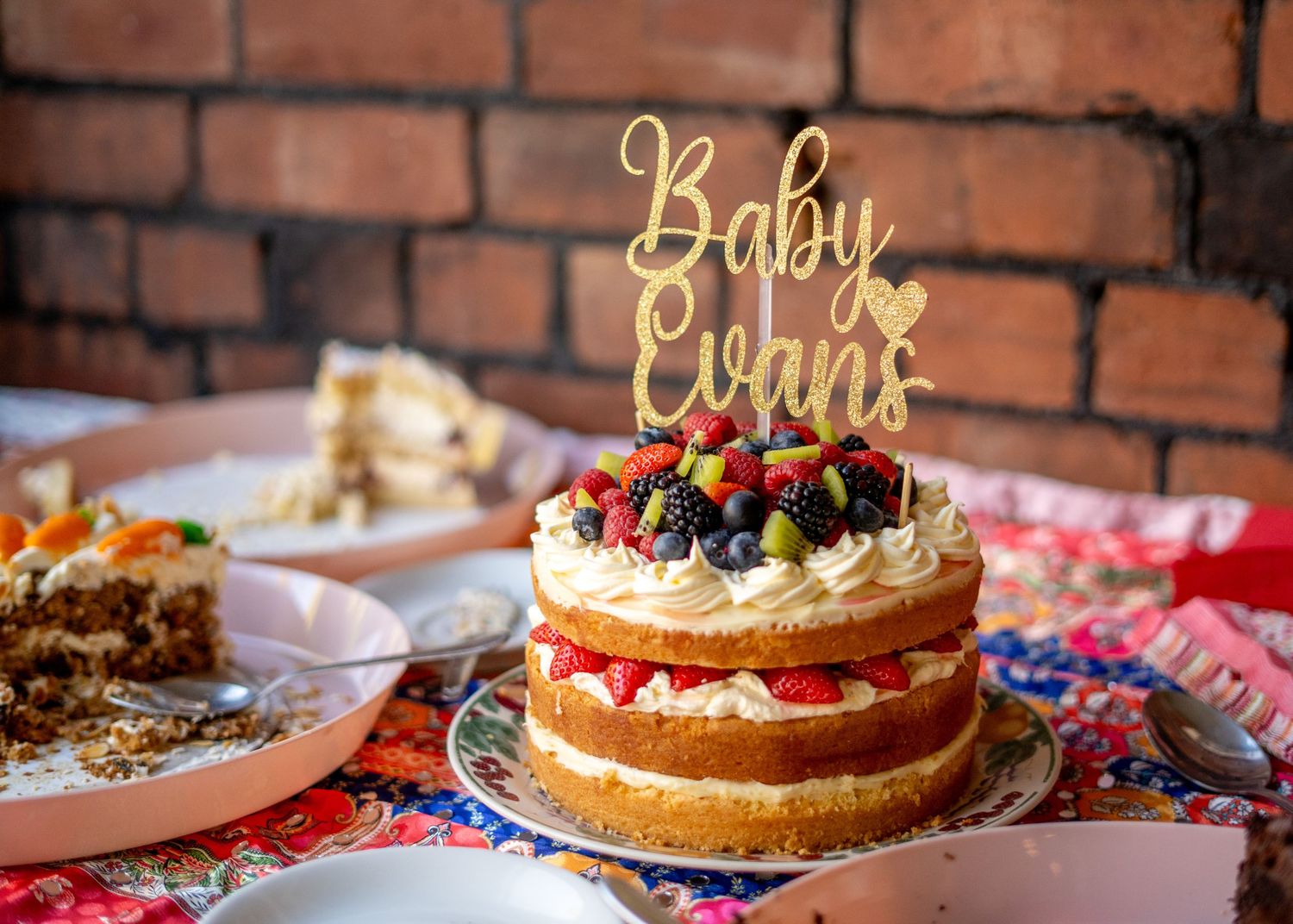 A group of guests enjoying a baby shower celebration at an indoor venue.