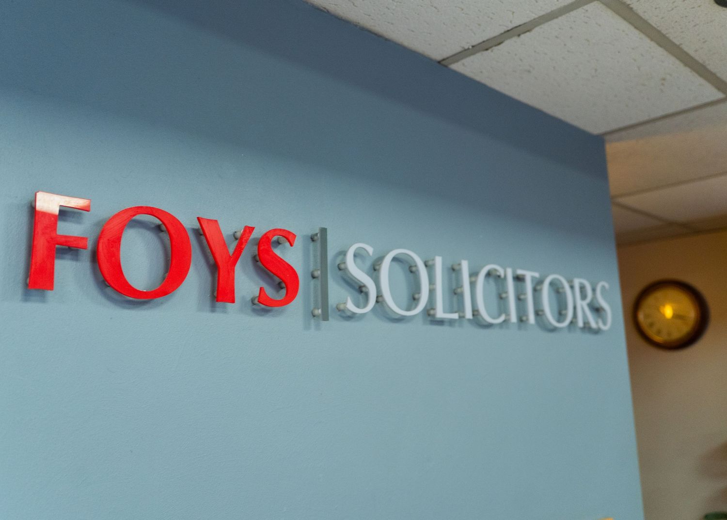 Professional office space with Foys Solicitors branding on light blue walls.