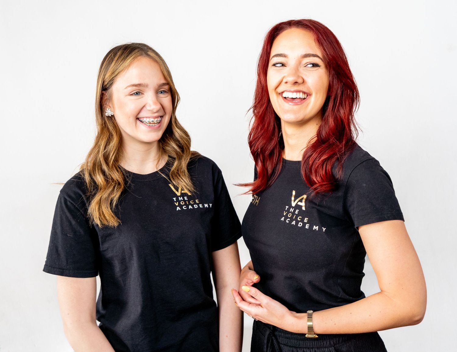 Students in matching black shirts sharing a lighthearted moment.