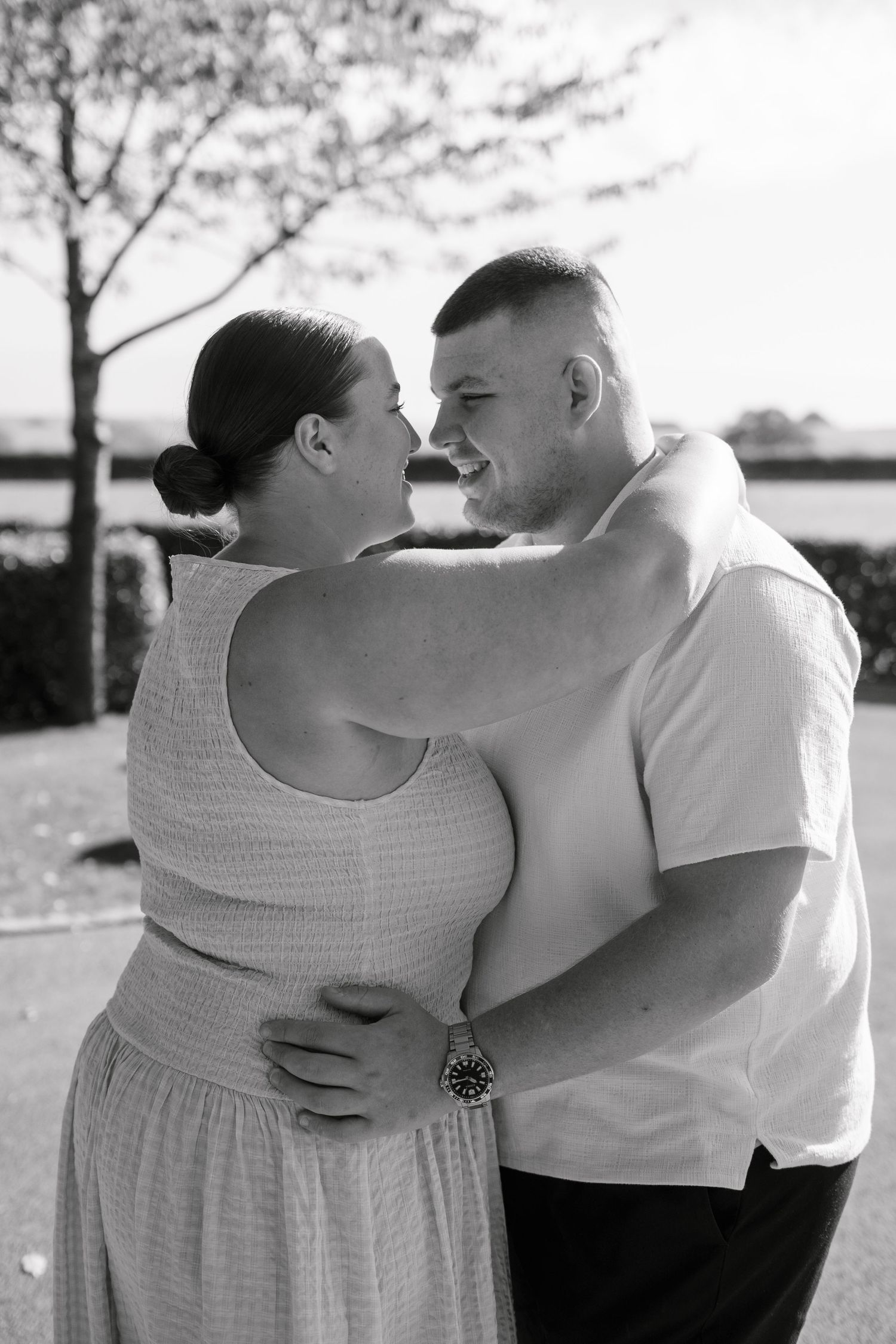 Romantic black and white portraits of couple embracing outdoors.
