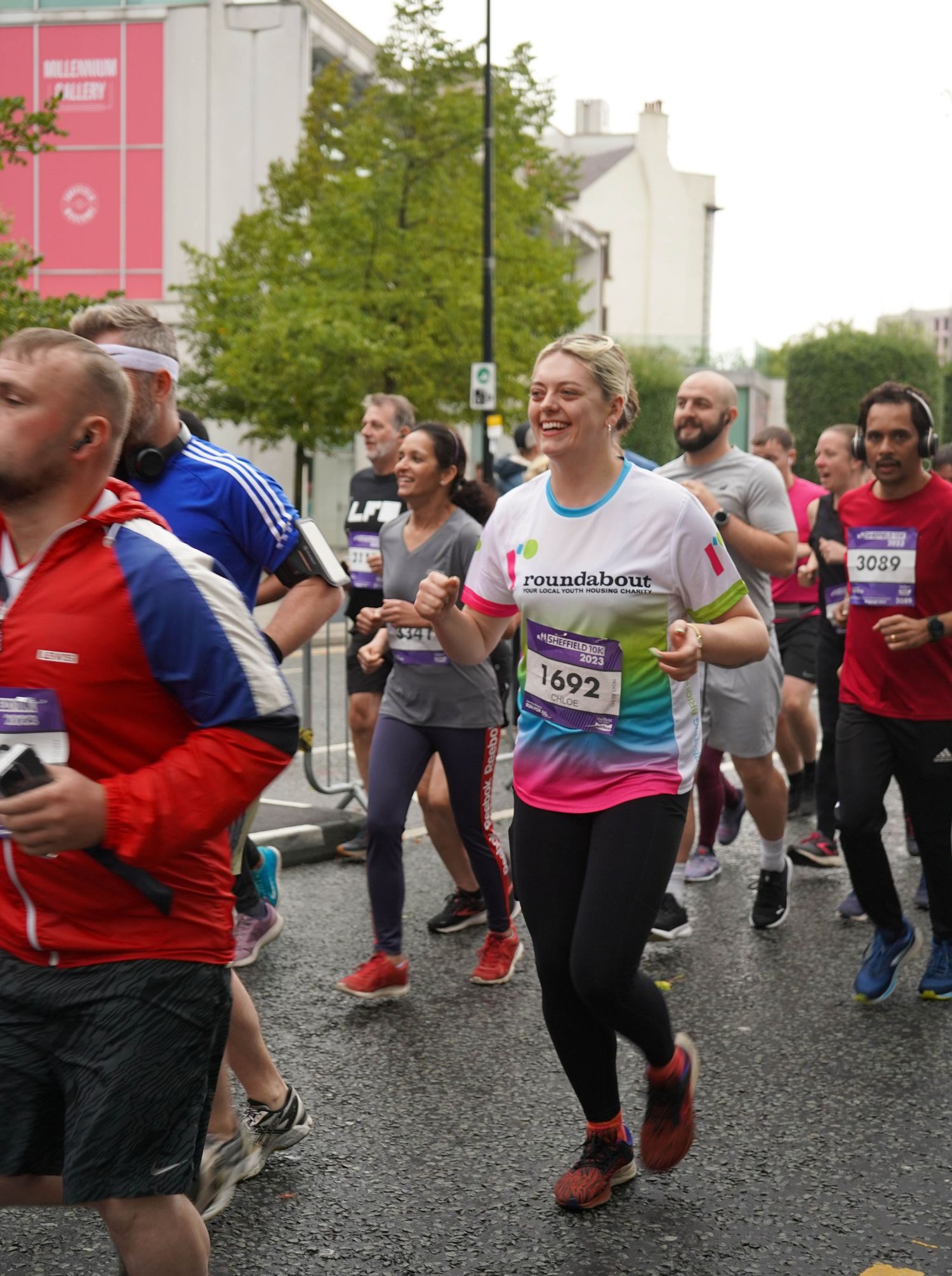 Group of marathon participants running together on a paved road during an organized race event.