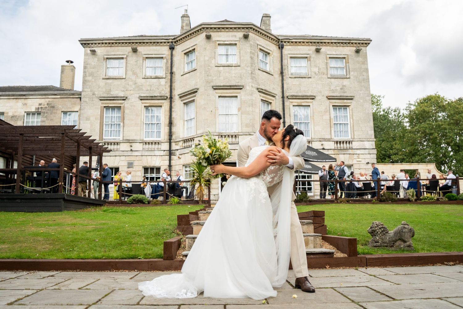 Wedding celebration at an elegant stone manor house with expansive grounds and classic architecture.