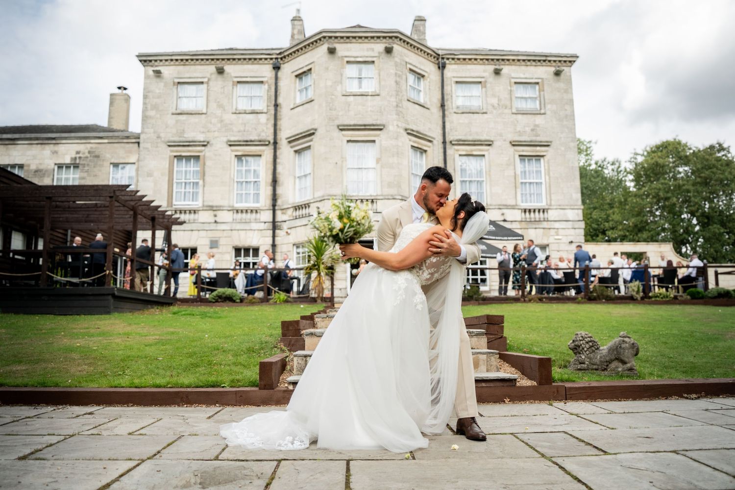 Elegant stone mansion serves as backdrop for outdoor wedding celebration.