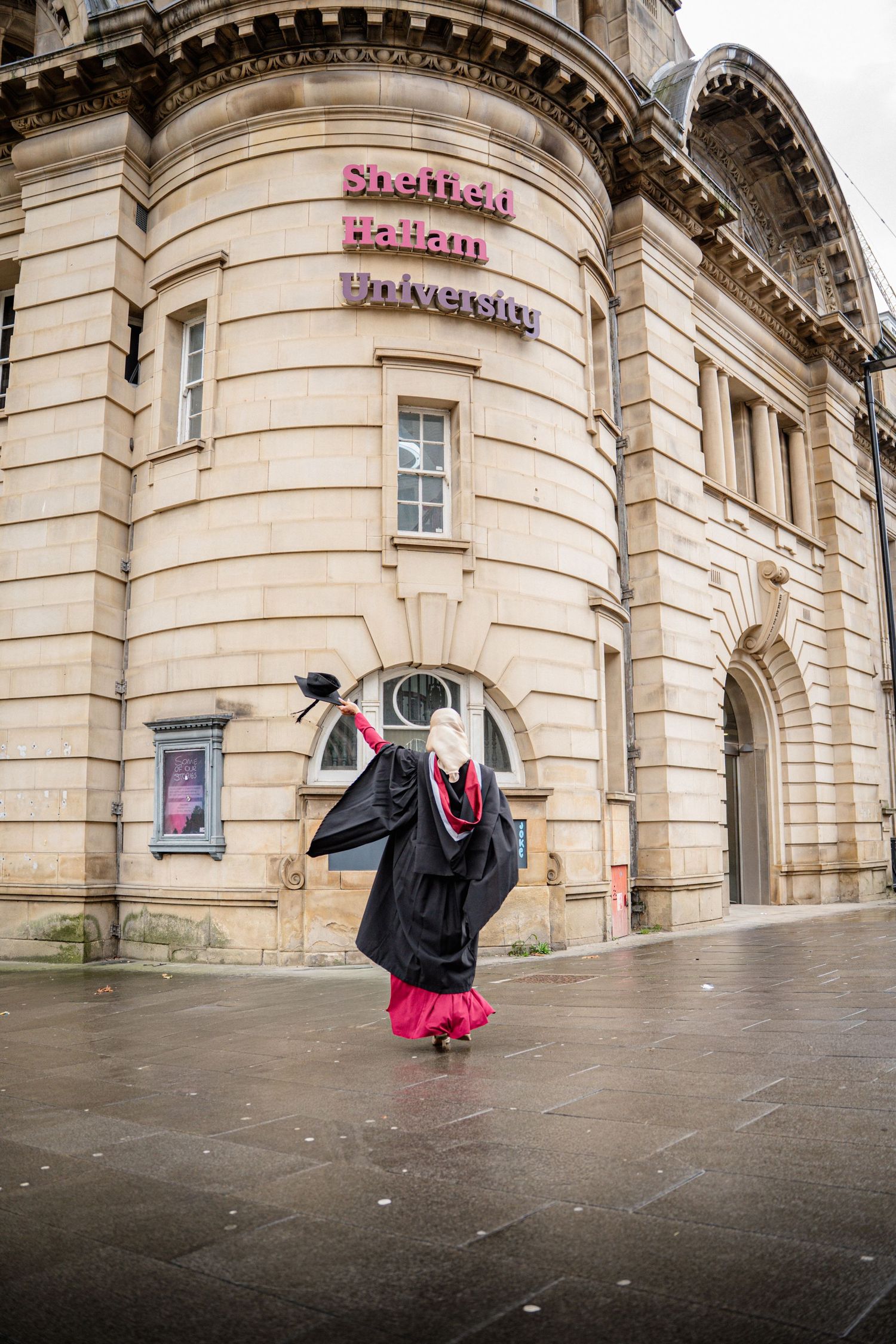 Graduation photoshoot outside historic stone building with classical architecture and columns.