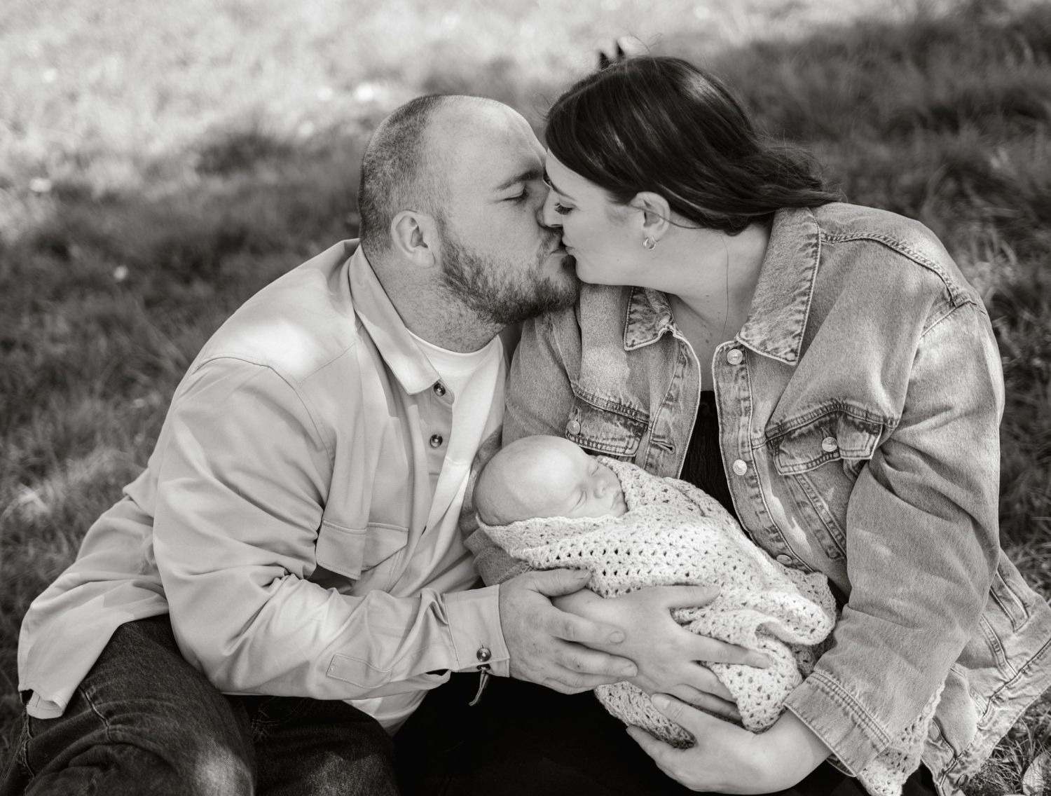 Black and white portrait of a tender family moment outdoors.