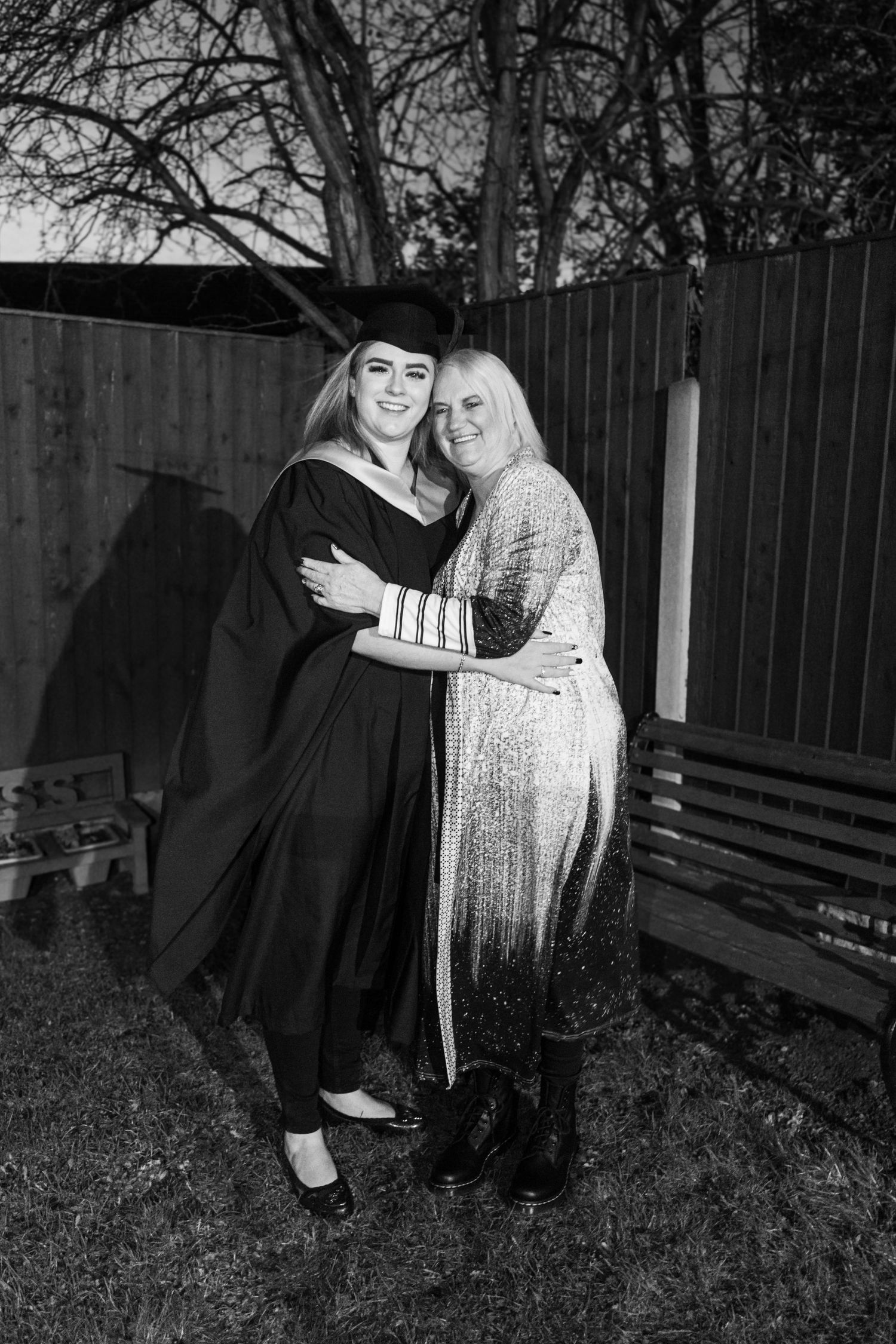Black and white graduation photos captured in an outdoor setting with natural backdrop.