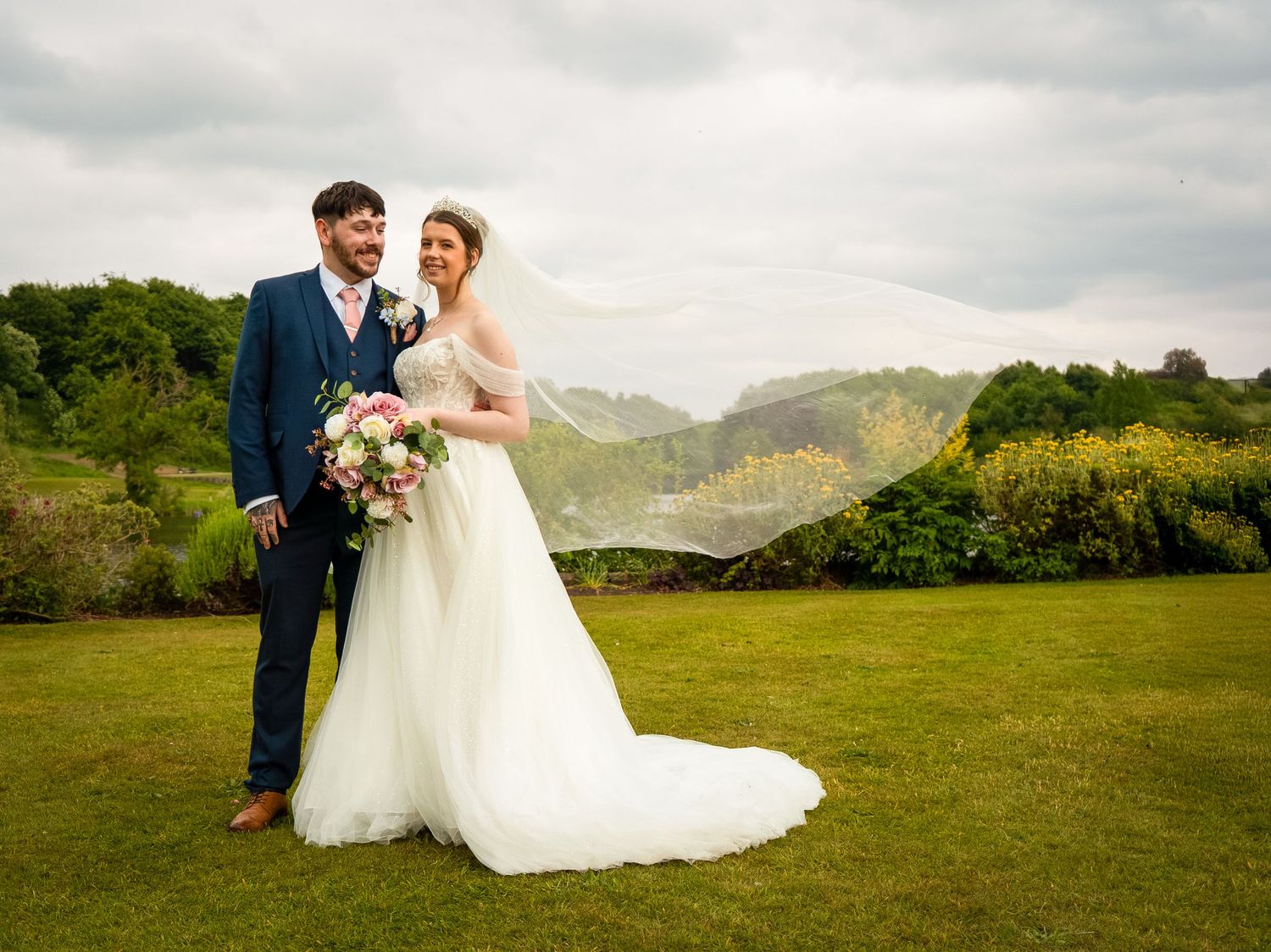 Romantic wedding photos taken in a scenic countryside landscape with rolling hills in the background.