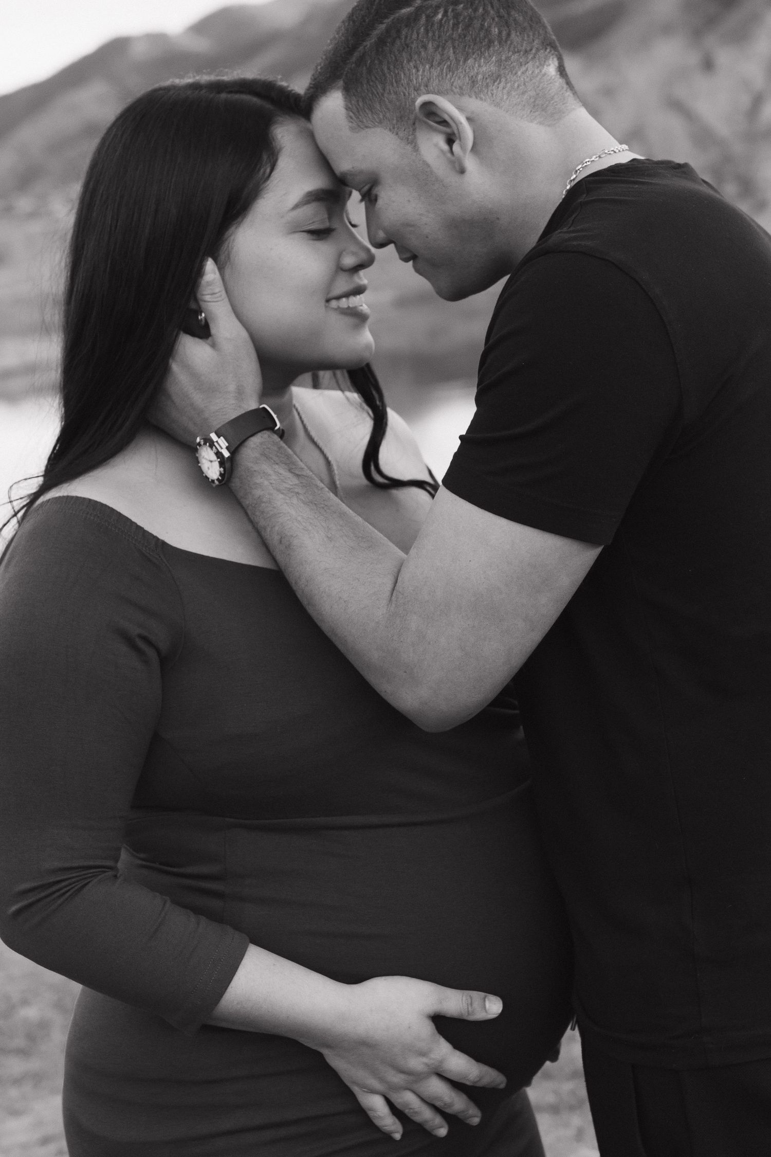 Expecting couple sharing a tender moment during an intimate black and white maternity photography session
