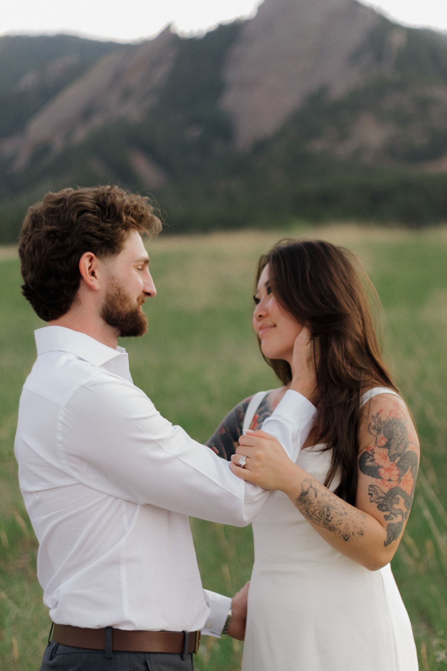 Couple sharing a tender moment together with dramatic mountain peaks in the background during a natural couples photography session