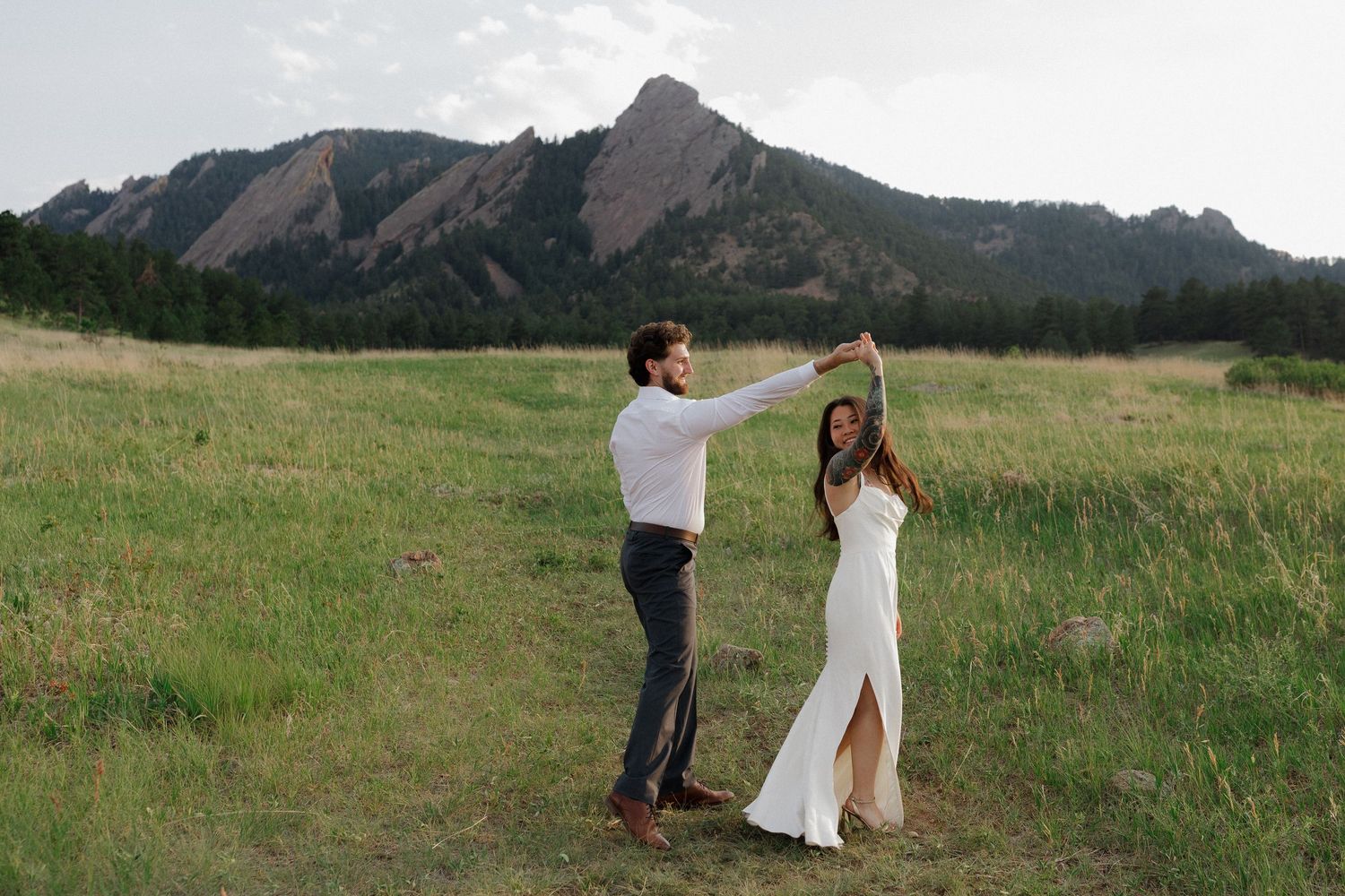 Engaged couple walking together through a Colorado mountain meadow during a natural and romantic engagement photography session