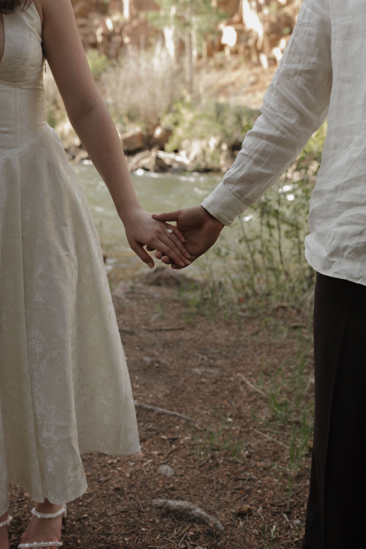 Couple holding hands together in a quiet forest during an intimate couples photography session