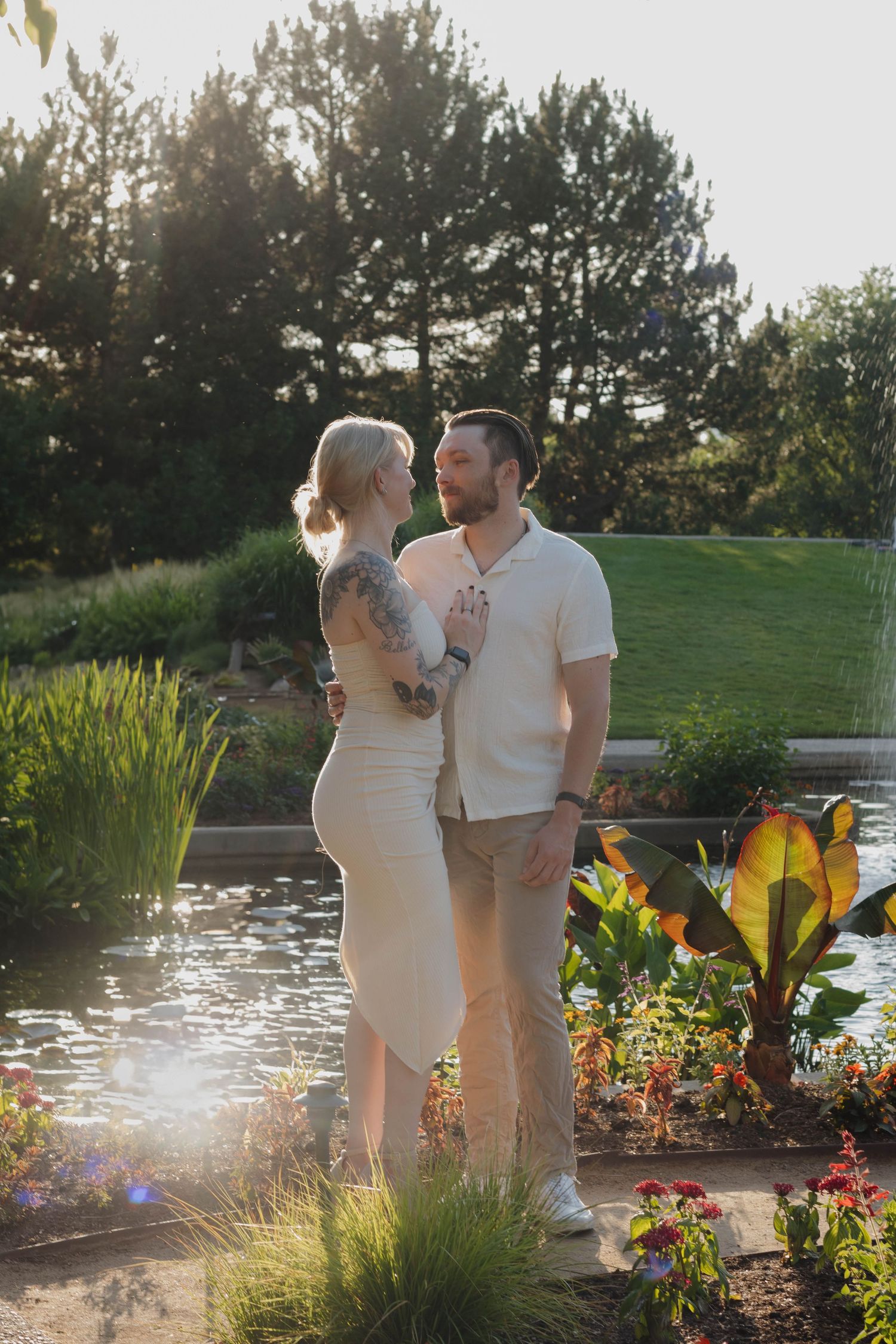 Couple walking together through a sunlit garden during a warm and natural couples photography session
