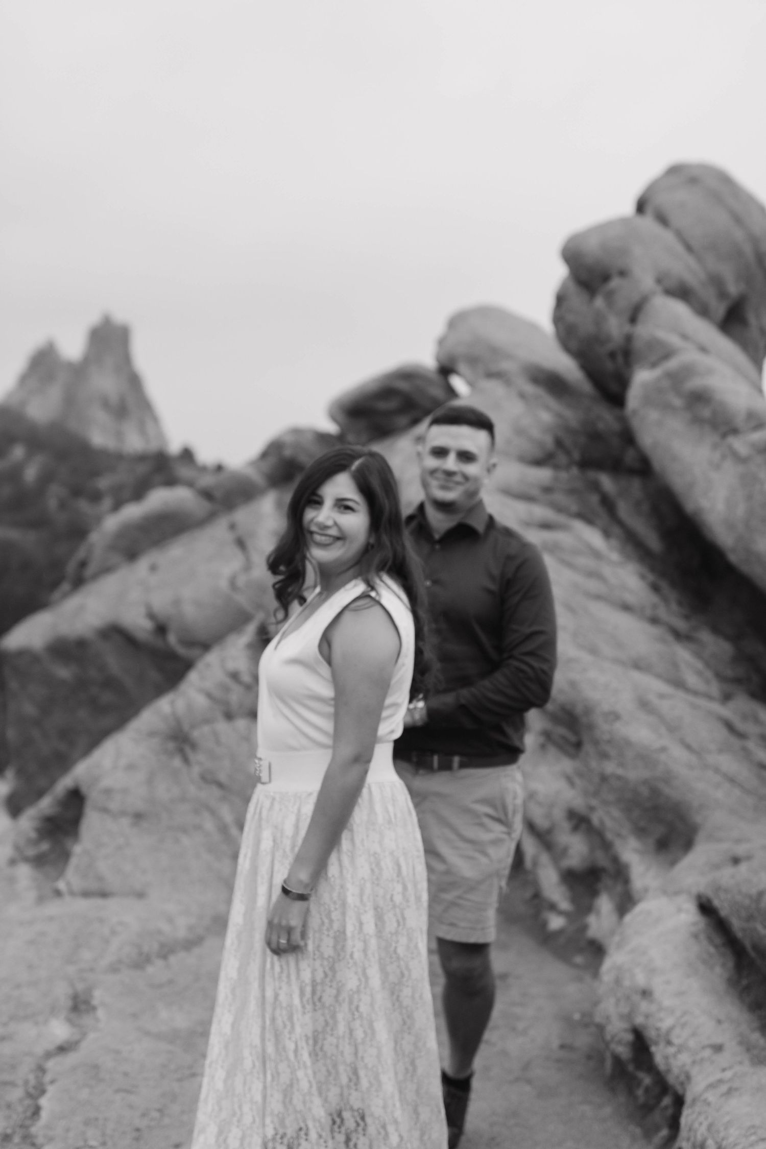 Couple embracing among dramatic rock formations during an intimate black and white couples photography session