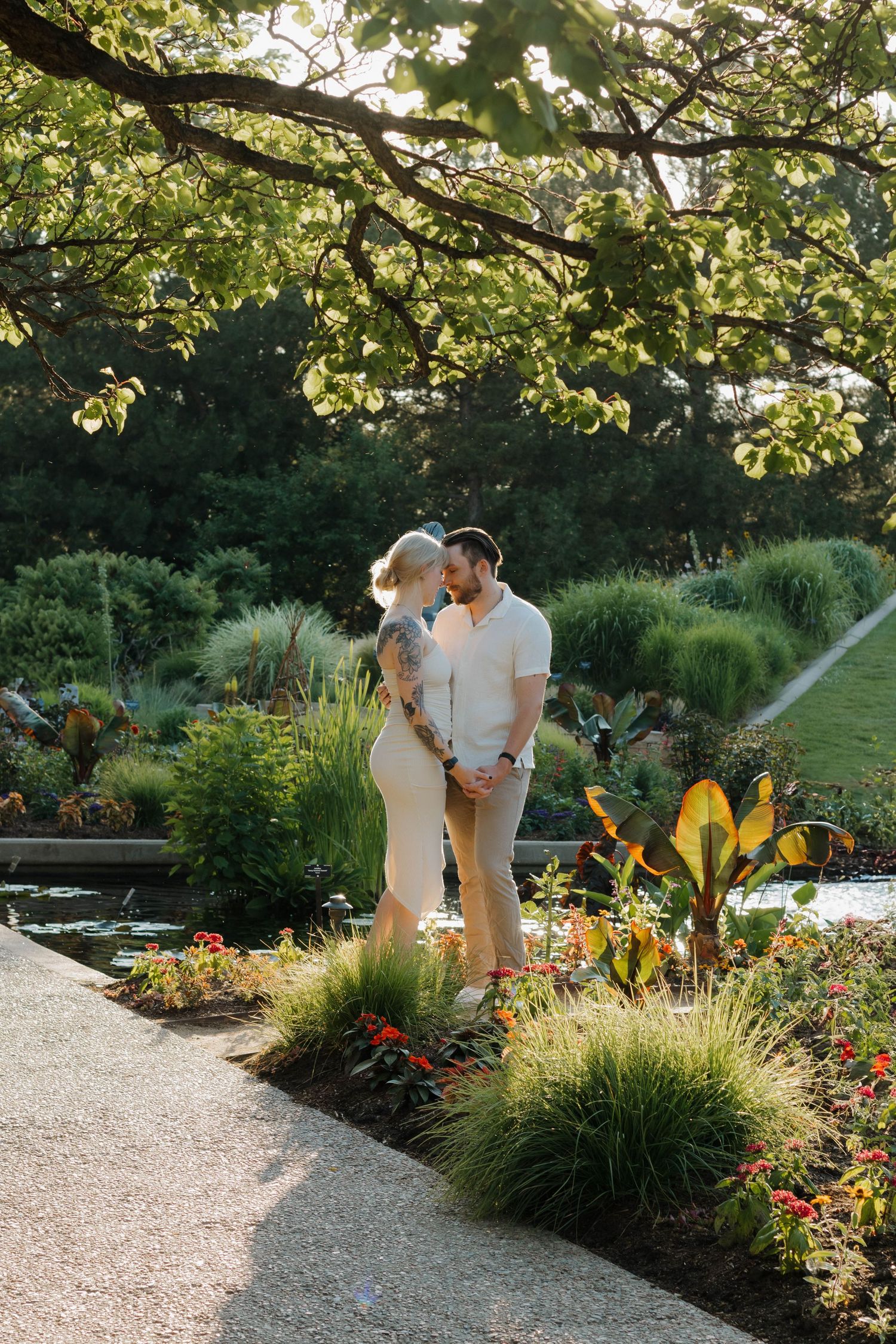 Couple walking together through a lush garden during a warm and natural couples photography session